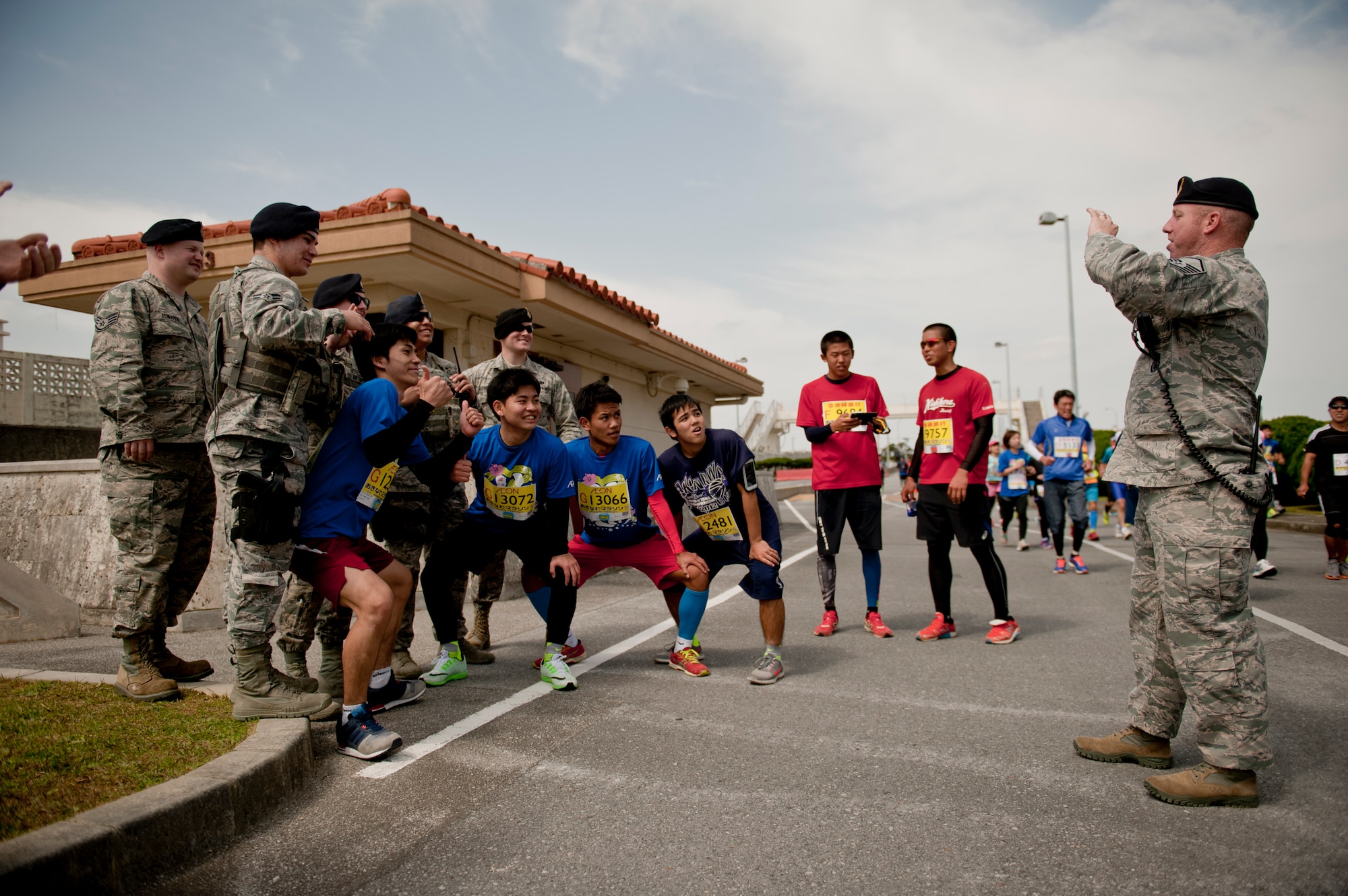 Runners take group photos with 18th Security Forces Squadron Airmen during the Okinawa Marathon Feb. 21, 2016 at Kadena Air Base, Japan. 18th SFS members provided traffic management on base and ensured the safety for runners. (U.S. Air Force photo by Senior Airman Peter Reft)