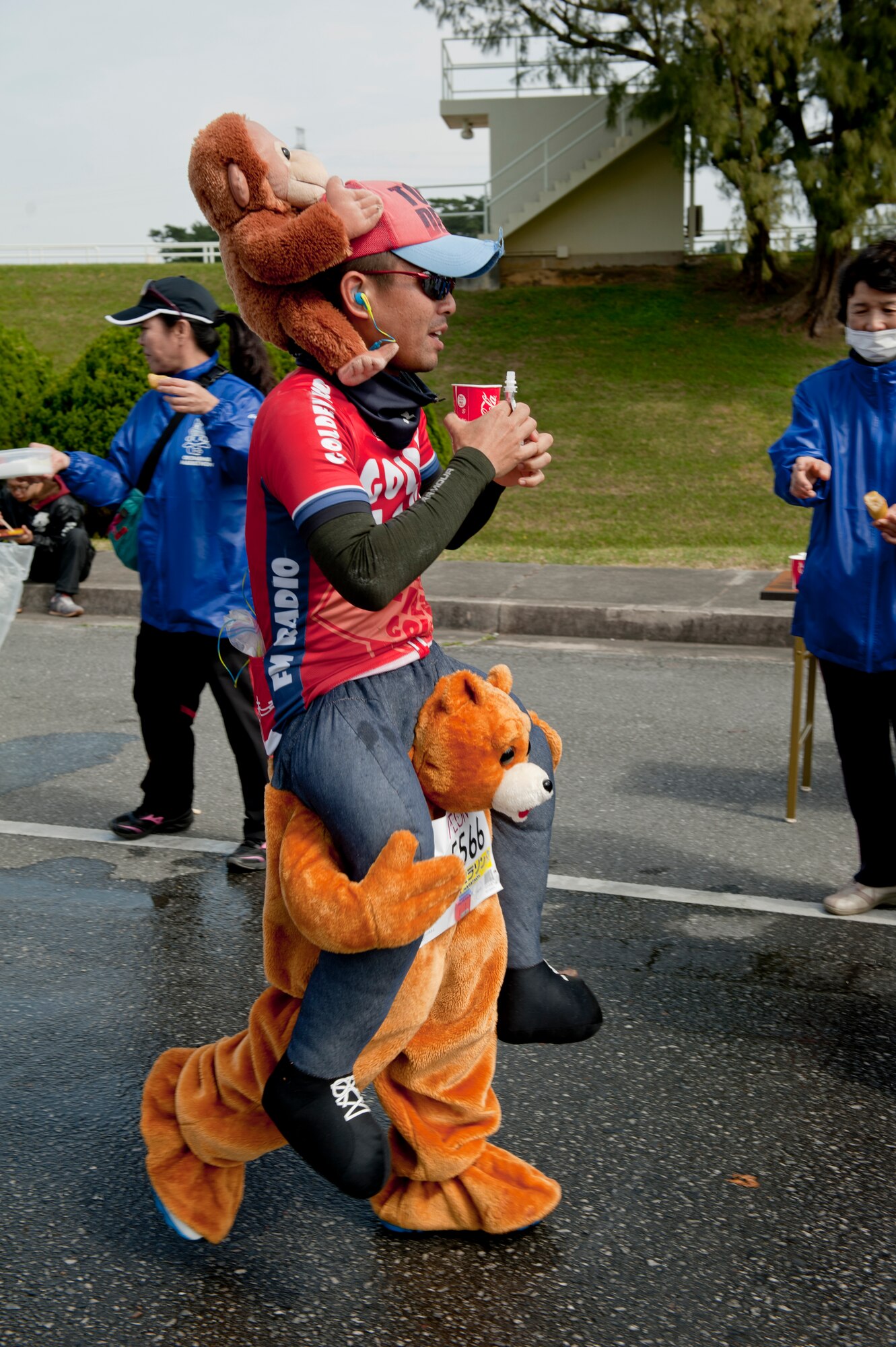 A costumed runner passes a water station during the Okinawa Marathon Feb. 21, 2016 at Kadena Air Base, Japan. The annual Okinawa Marathon is one of two full marathons in Okinawa, and is the only marathon in Japan to feature a route section on a military installation. (U.S. Air Force photo by Senior Airman Peter Reft)