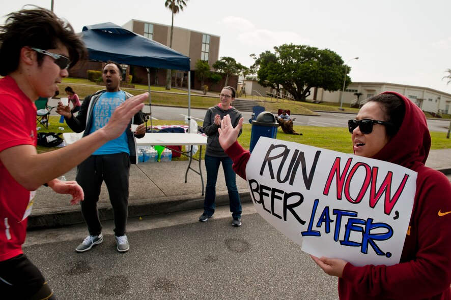 Team Kadena members cheer on runners during the Okinawa Marathon Feb. 21, 2016, at Kadena Air Base, Japan. Kadena hosted a two-kilometer section of the marathon route, providing cheer stations, water stations and medical support. (U.S. Air Force photo by Senior Airman Peter Reft)