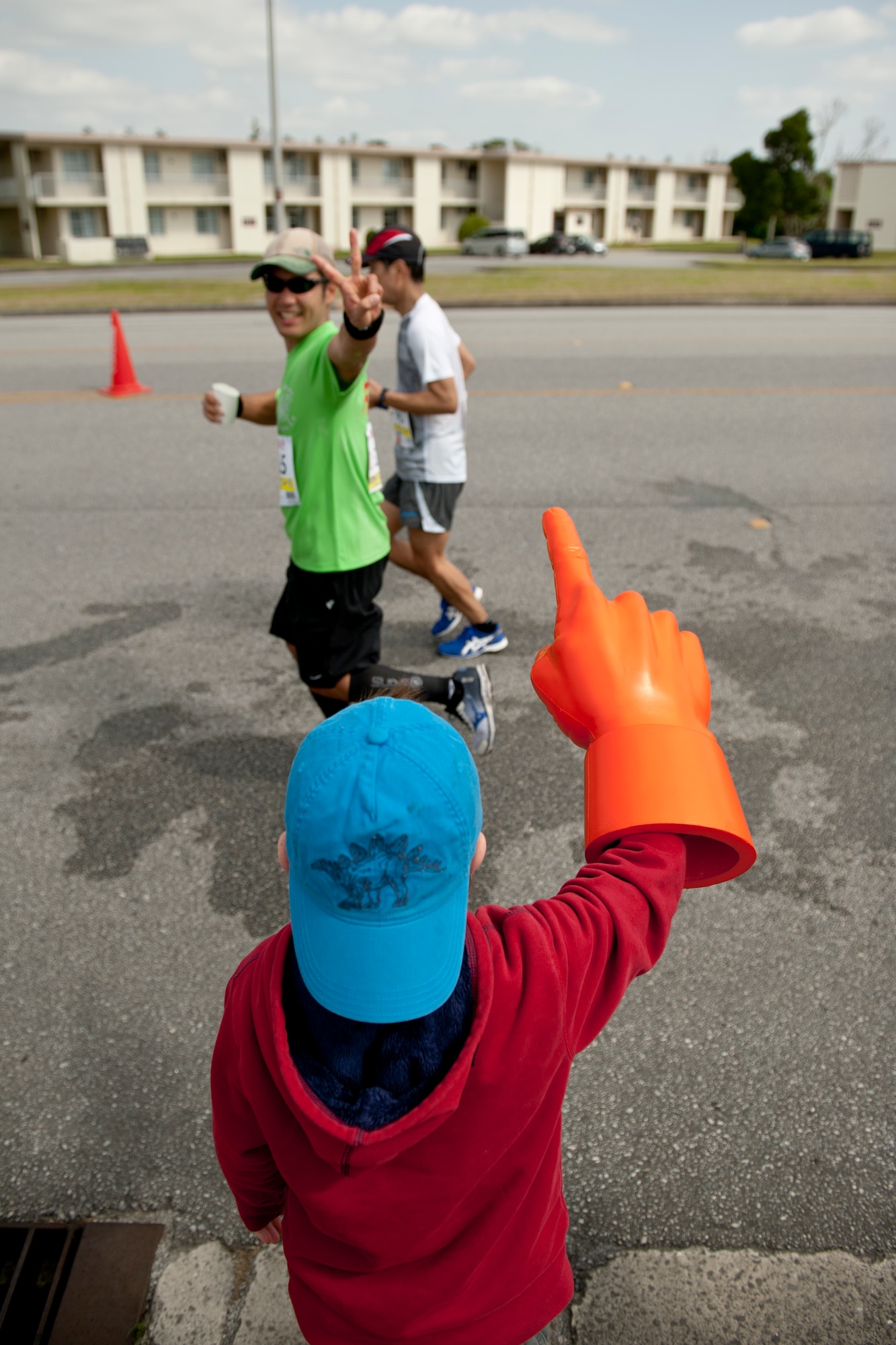 A Team Kadena family member cheers on runners during the Okinawa Marathon Feb. 21, 2016, at Kadena Air Base, Japan. Along the two-kilometer section through Kadena, base residents cheered and rallied for runners, while also providing water stations and medical support. (U.S. Air Force photo by Senior Airman Peter Reft)