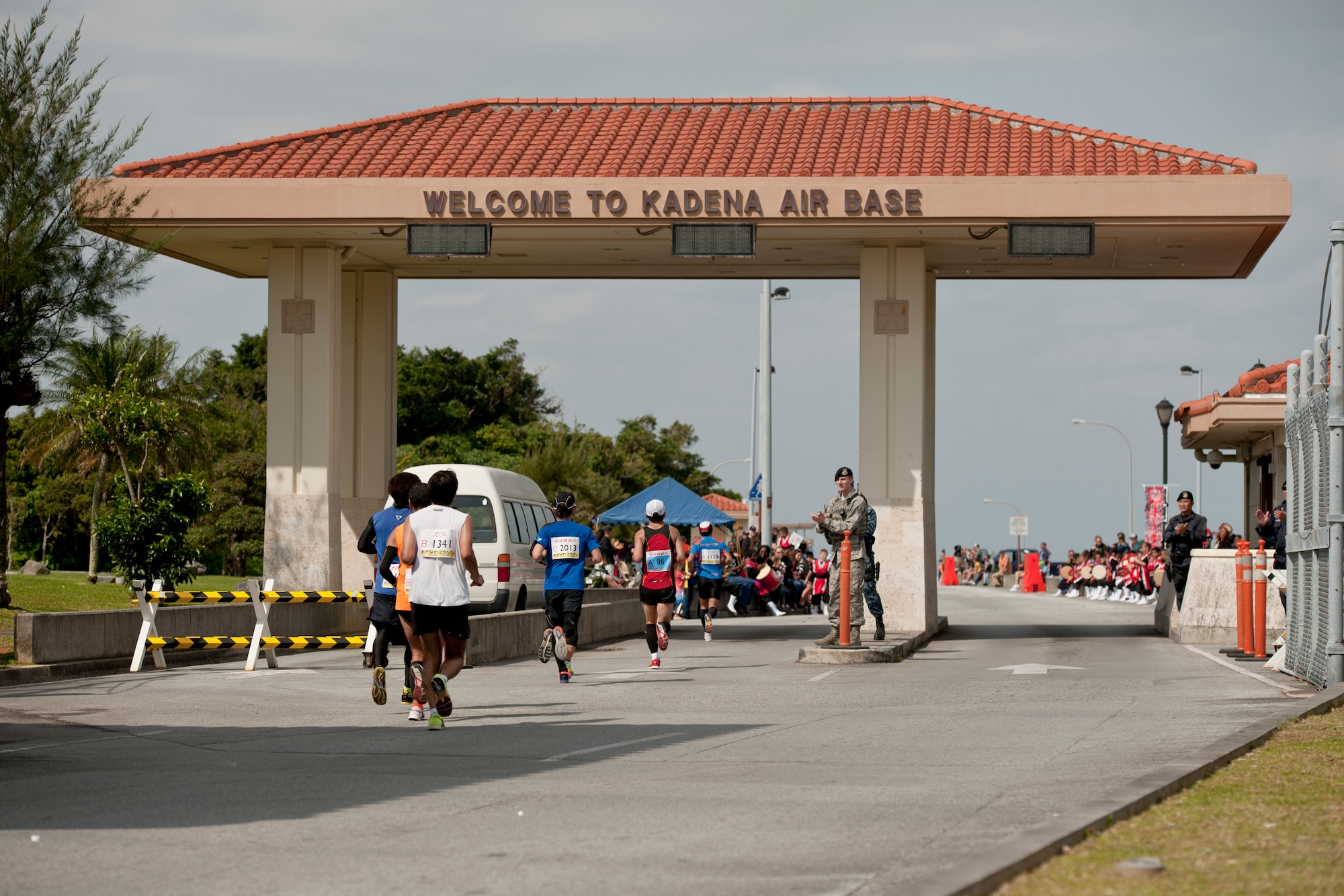 Runners enter Kadena Air Base during the Okinawa Marathon Feb. 21, 2016, at Kadena Air Base, Japan. Kadena hosted a two-kilometer section of the marathon route, providing cheer stations, water stations and medical support. (U.S. Air Force photo by Senior Airman Peter Reft)