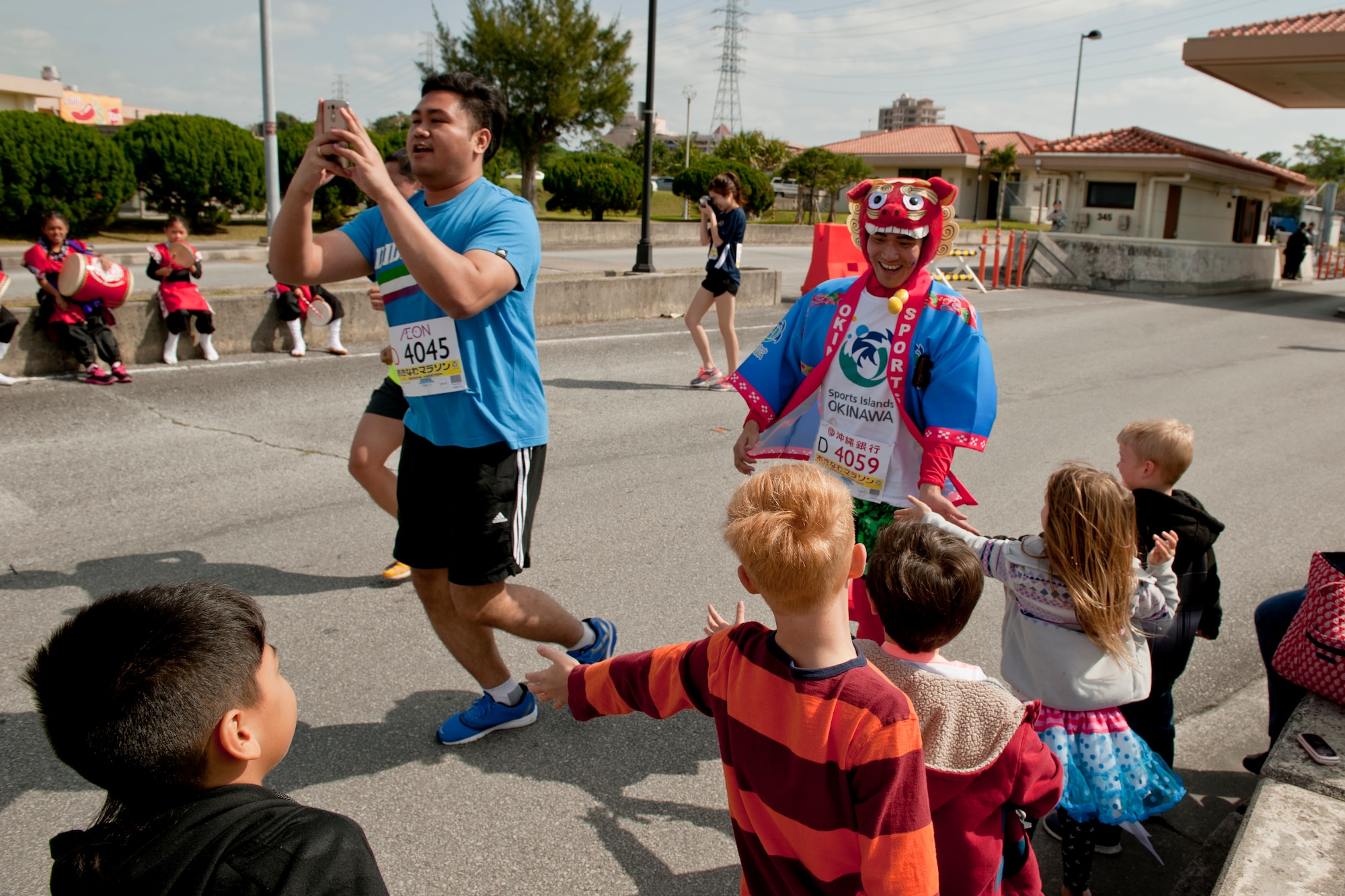 Team Kadena crowd members greet runners during the Okinawa Marathon Feb. 21, 2016, at Kadena Air Base, Japan. As part of a wide-reaching community relations program, Kadena is the only military base to participate with hosting marathons in Japan. (U.S. Air Force photo by Senior Airman Peter Reft)
