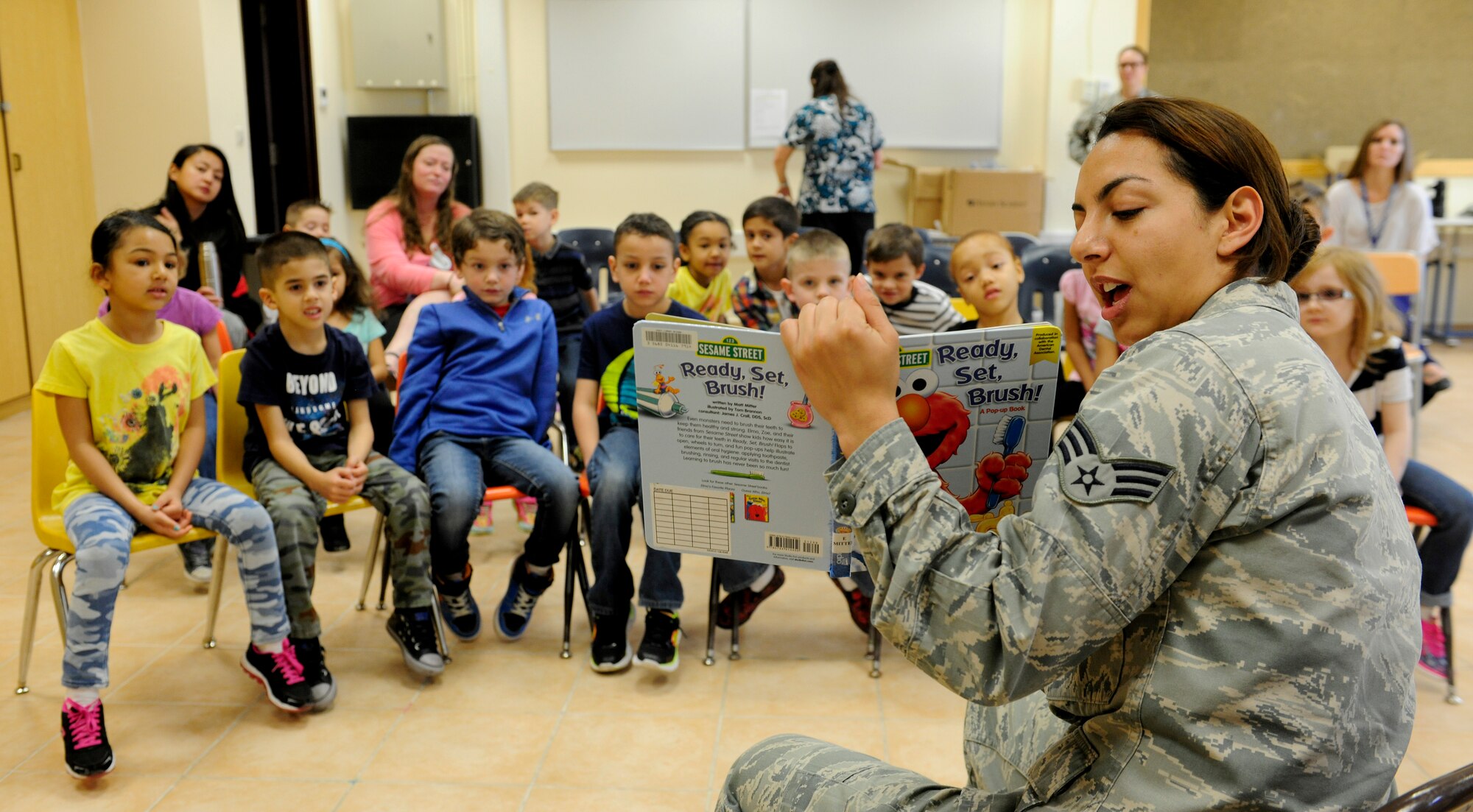 U.S. Air Force Senior Airman Ana Gomez-Martinez, 39th Medical Operations Squadron oral preventative technician, reads a book about dental health to children at Incirlik Unit School Feb. 19, 2016, at Incirlik Air Base, Turkey. Members of the dental flight reviewed how foods and tooth care affect oral health. (U.S. Air Force photo by Staff Sgt. Jack Sanders)
