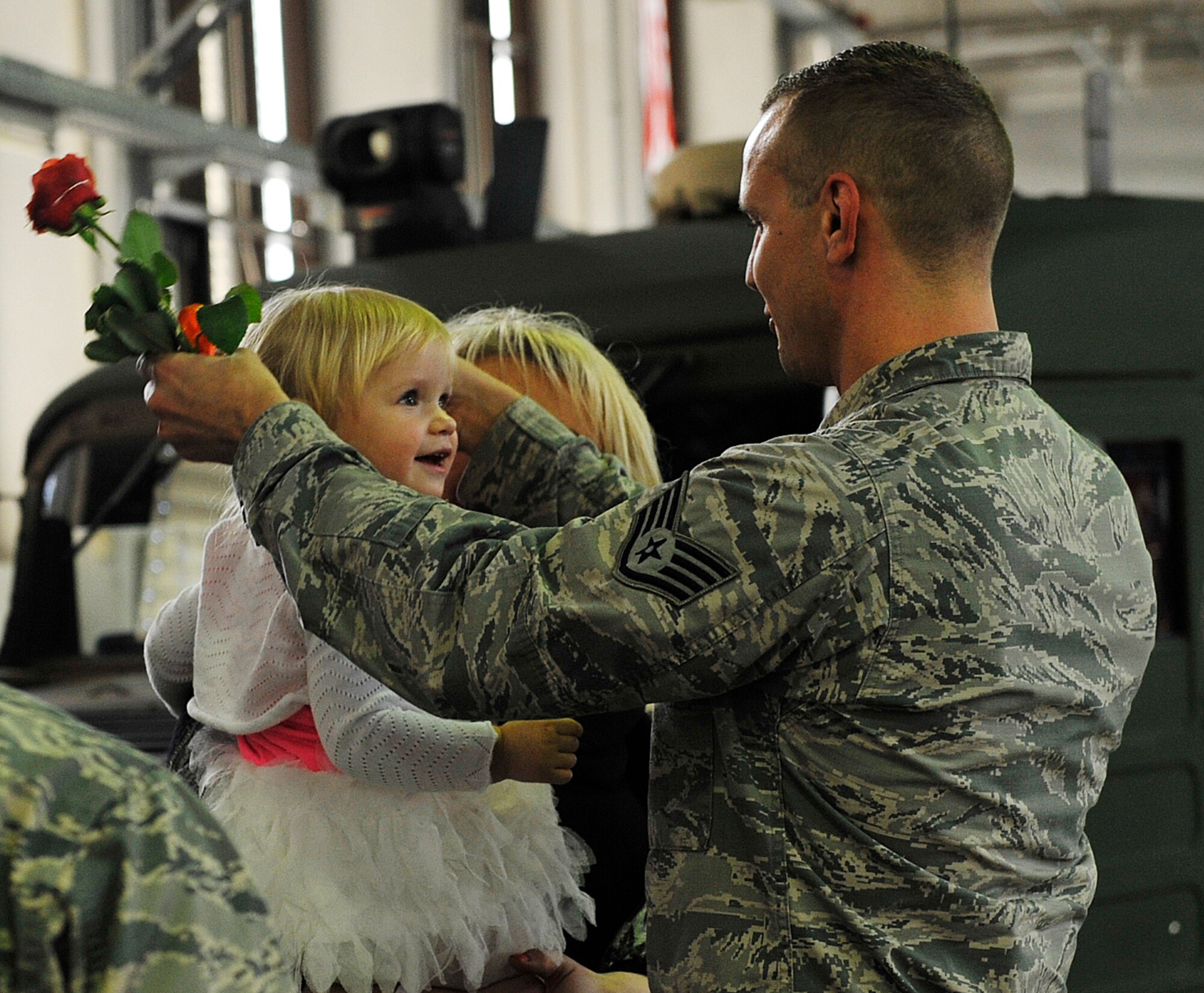 Staff Sgt. Ivor Mueller, 86th Vehicle Readiness Squadron equipment support assistant, places a medal around the neck of his daughter, Kitana, during a Homefront Heroes ceremony Feb. 19, 2016, at Ramstein Air Base, Germany. The ceremony honors children and spouses for the sacrifices they make while their family member is deployed. (U.S. Air Force photo/Airman 1st Class Larissa Greatwood)