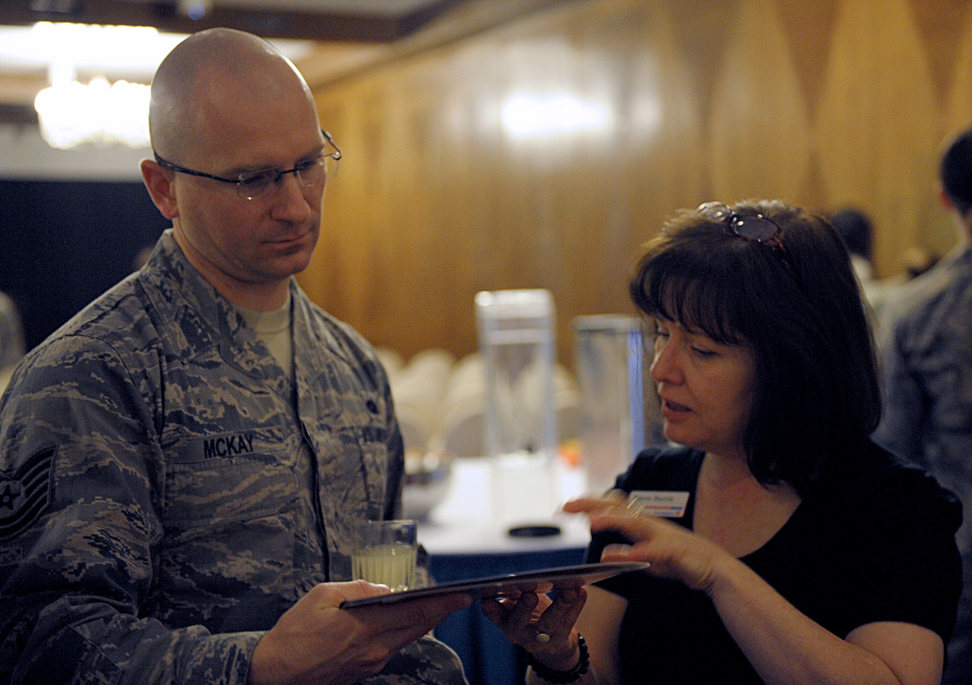Tech. Sgt. Maurice McKay, 2nd Air Postal Squadron, speaks to Karen Harris, Community Bank, about a savings guide at the Military Saves Week kickoff Feb. 19, 2016, at Ramstein Air Base, Germany. During the event, Kaiserslautern Military Community members learned about saving plans and signed up through several financial institutions. The theme for the 2016 Military Saves Week is “Make Saving Automatic.” (U.S. Air Force photo/Staff Sgt. Timothy Moore)
