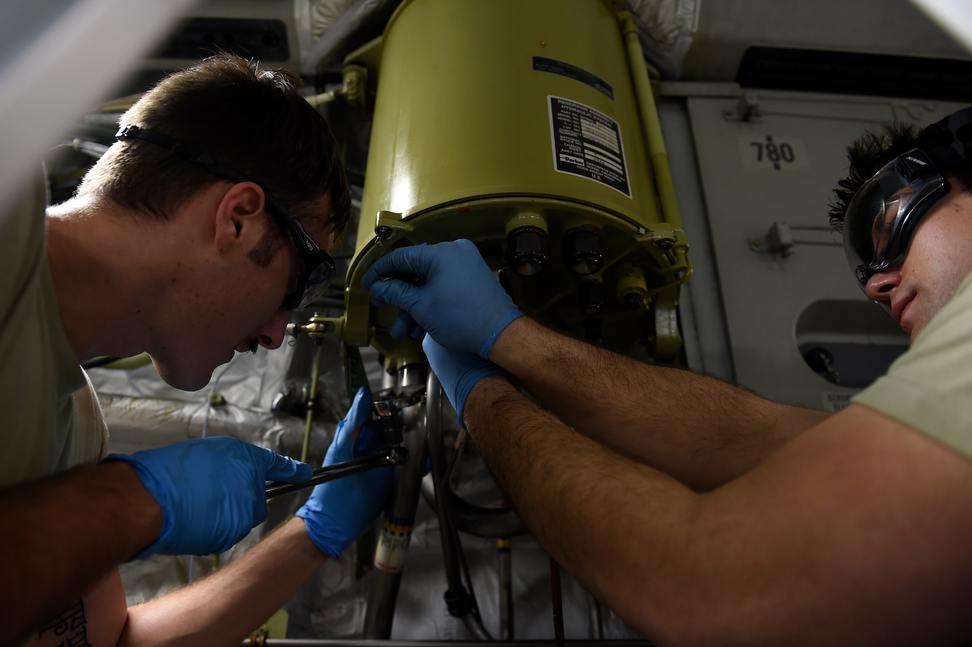 Senior Airman Jacob Remstrom (right) and Staff Sgt. Nathan Kuhn, 62nd Maintenance Squadron hydraulics systems specialists, remove a broken hydraulic reservoir on a C-17 Globemaster III, Feb. 18, 2016 at North Island Naval Station, Calif. Remstrom and Kuhn were two members of a McChord Maintenance Recovery Team sent from Joint Base Lewis-McChord, Wash., to repair the C-17. (U.S. Air Force photo/Tech Sgt. Tim Chacon)
