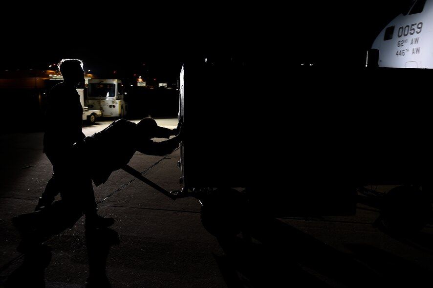 Senior Airman Jacob Remstrom, 62nd Maintenance Squadron, and Staff Sgt. Tanner Evjene (front), 62nd Aircraft Maintenance Squadron crew chief, move a hydraulic’s cart into position at North Island Naval Station, Calif. The cart was used to add and empty hydraulic fluids on a C-17 Globemaster III. (U.S. Air Force photo/Tech Sgt. Tim Chacon)