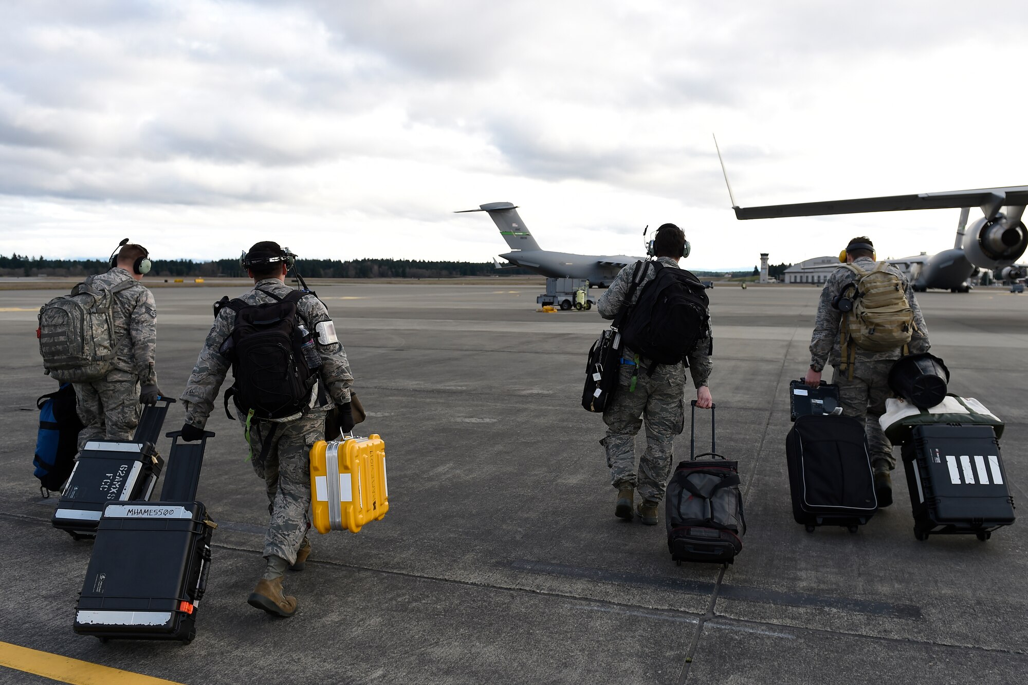 A four person McChord Maintenance Recovery Team walks to a C-17 Globemaster III Feb. 18, 2016 on Joint Base Lewis-McChord, Wash. The team flew to North Island Naval Station, Calif., to repair a C-17 that had maintenance issues there. (U.S. Air Force photo/Tech Sgt. Tim Chacon)