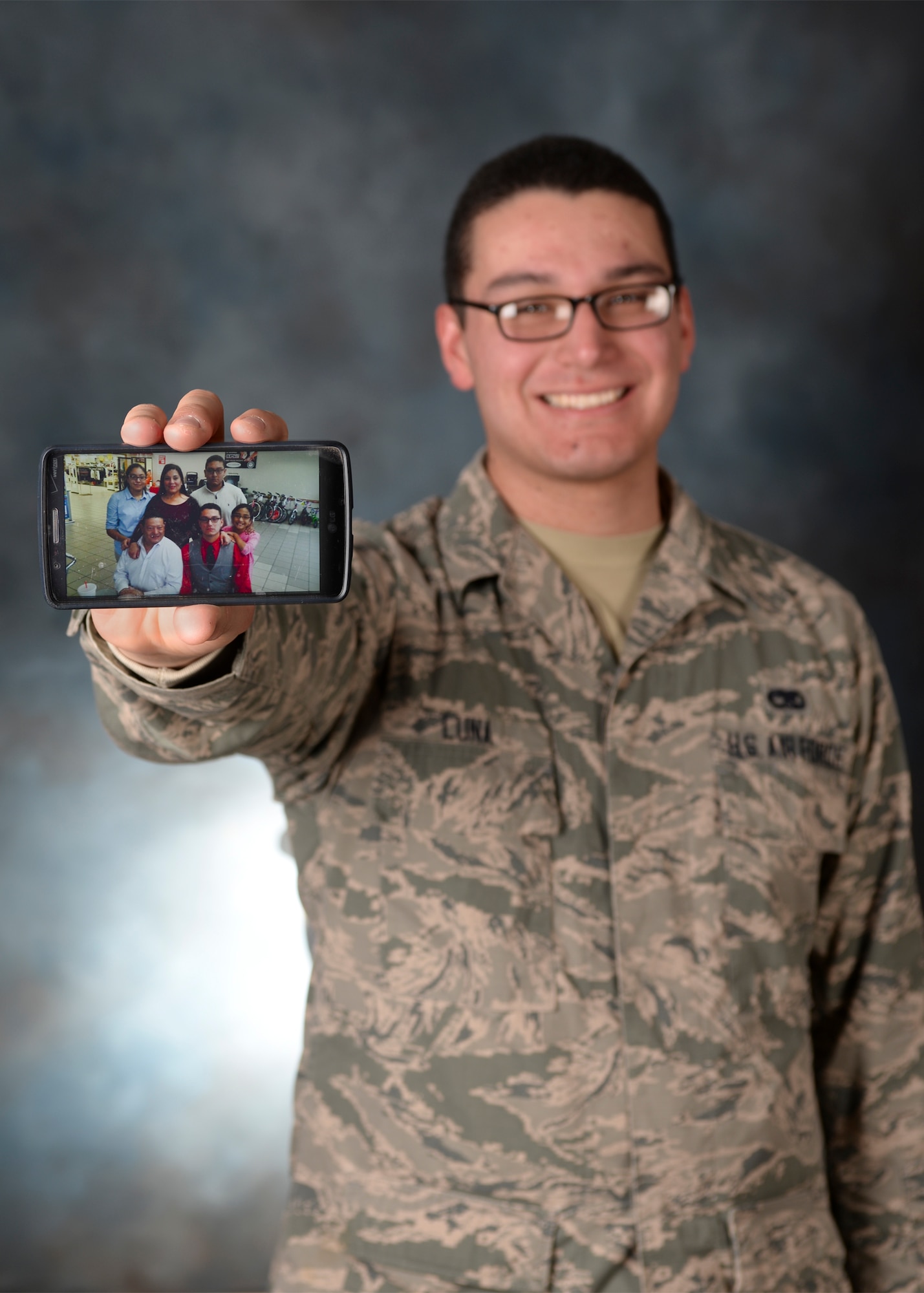 Airman 1st Class Ignacio Luna Jr., 28th Aircraft Maintenance Squadron weapons load crew member, proudly displays a photo of his family at Ellsworth Air Force Base, S.D., Feb. 10, 2016. Luna uses his family to motivate him to work hard and be the best Airman he can be. (U.S. Air Force photo by Airman Sadie Colbert/Released)