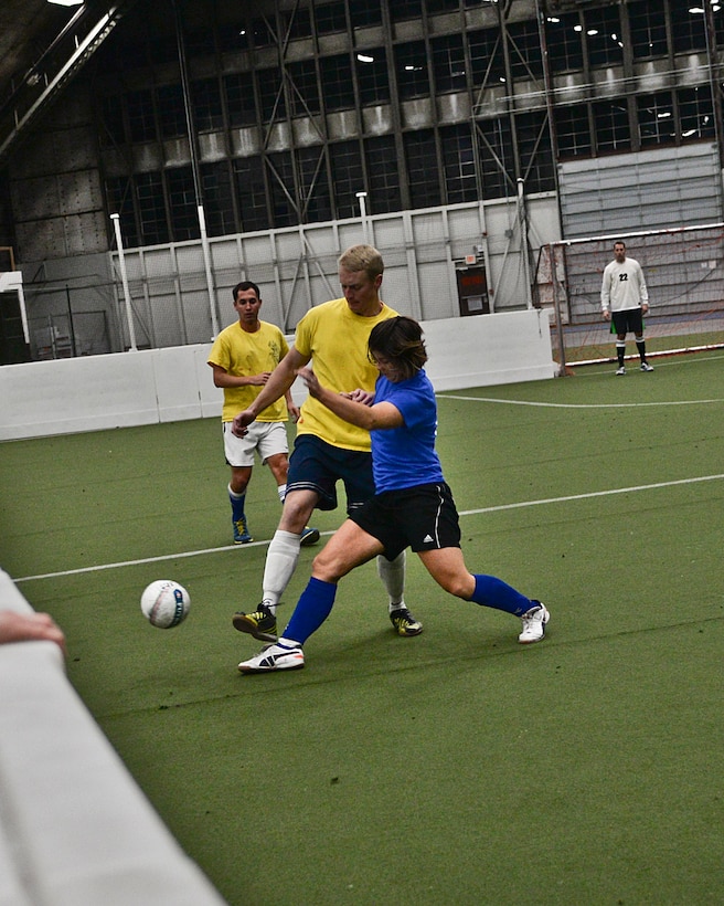 Capt. Jay, 37th Bomb Squadron pilot, left, hustles to get a ball away from an Airman of the 432nd Attack Squadron during an intramural soccer game at Ellsworth Air Force Base, S.D., Feb. 16, 2016. Ellsworth’s recreational soccer teams play in the Pride Hangar every Monday through Thursday nights until the final four have earned spots in the playoffs. For more information on intramural sports programs, call (605) 385-2264. (U.S. Air Force photo by Airman Sadie Colbert/Released)