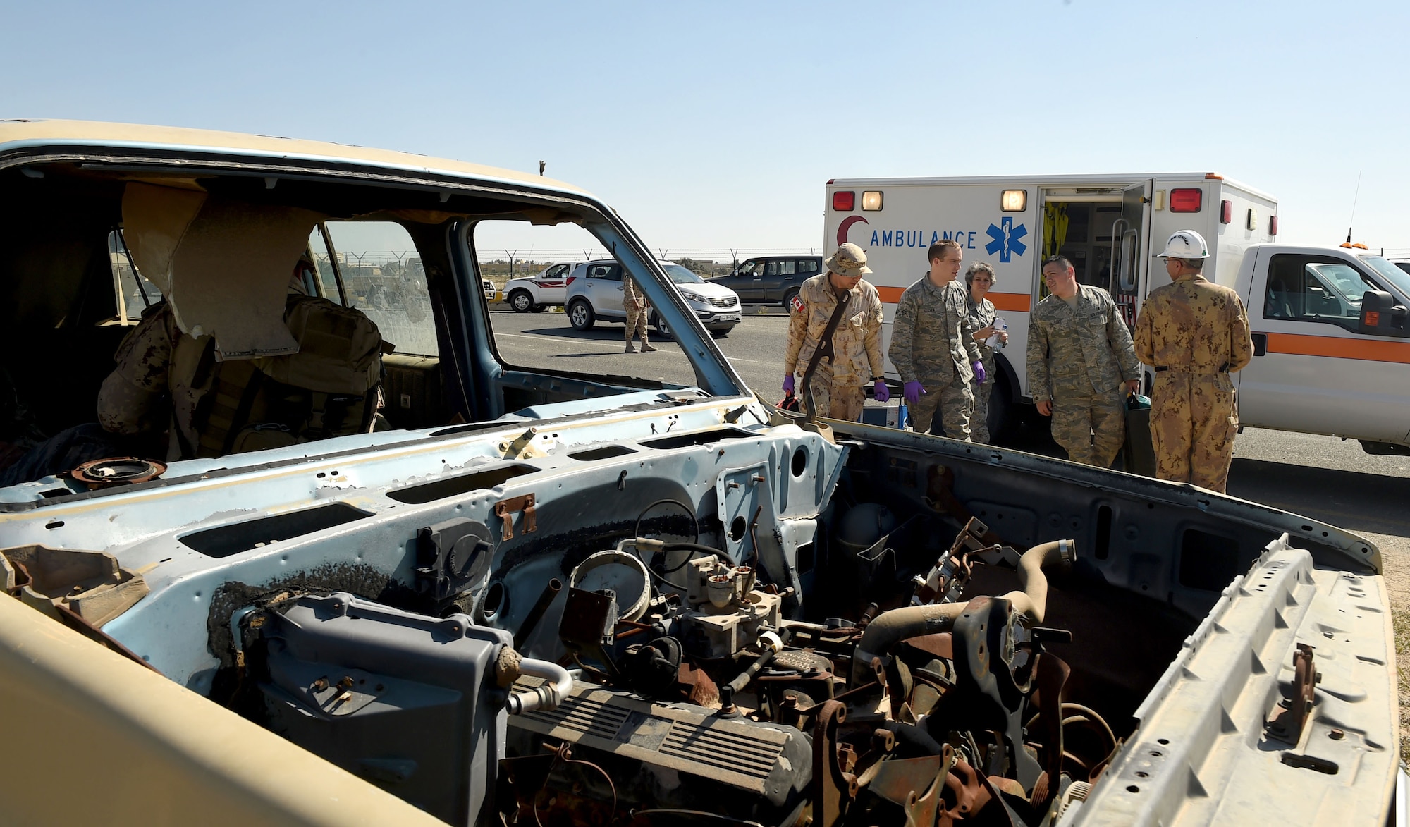 Medical personnel and firefighters from the 386th Air Expeditionary Wing and the Canadian Armed Forces work together to assess the scene of a simulated car crash at an undisclosed location in Southwest Asia, Feb. 18, 2016. The joint service exercise brought U.S. and coalition forces together to practice first response and medevac capabilities. (U.S. Air Force photo by Staff Sgt. Jerilyn Quintanilla)