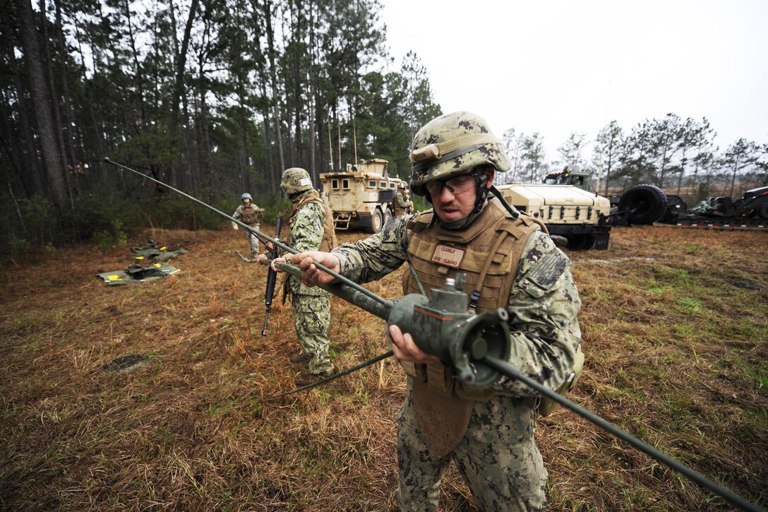 Navy Petty Officer 2nd Class Jacob Clark sets up communications equipment during field training exercises at Camp Shelby, Miss., Feb. 22, 2014. Clark is assigned to Naval Mobile Construction Battalion 11. Navy photo by Petty Officer 1st Class Michael C. Barton