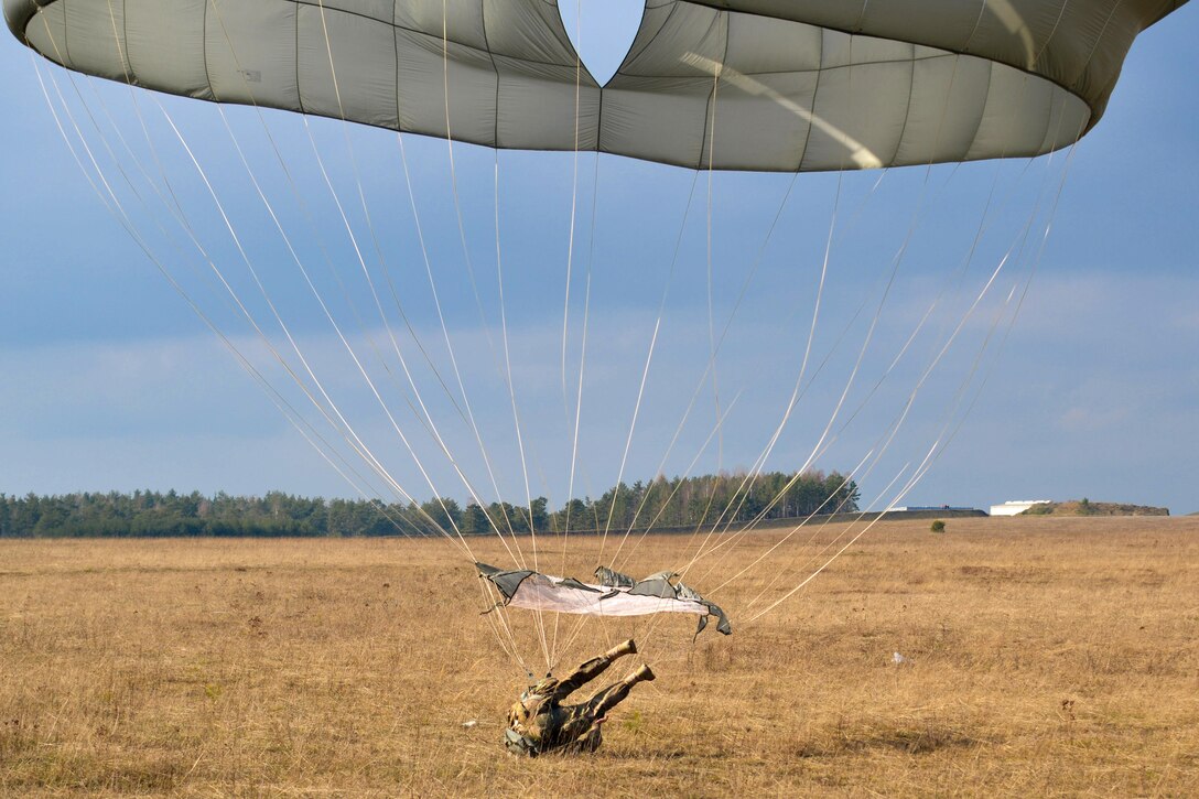 A paratrooper lands on Bunker drop zone after jumping from a UH-60 Black Hawk helicopter at Grafenwoehr Training Area, Germany, Feb. 18, 2016. Army photo by Sgt. Timothy MacDuffie