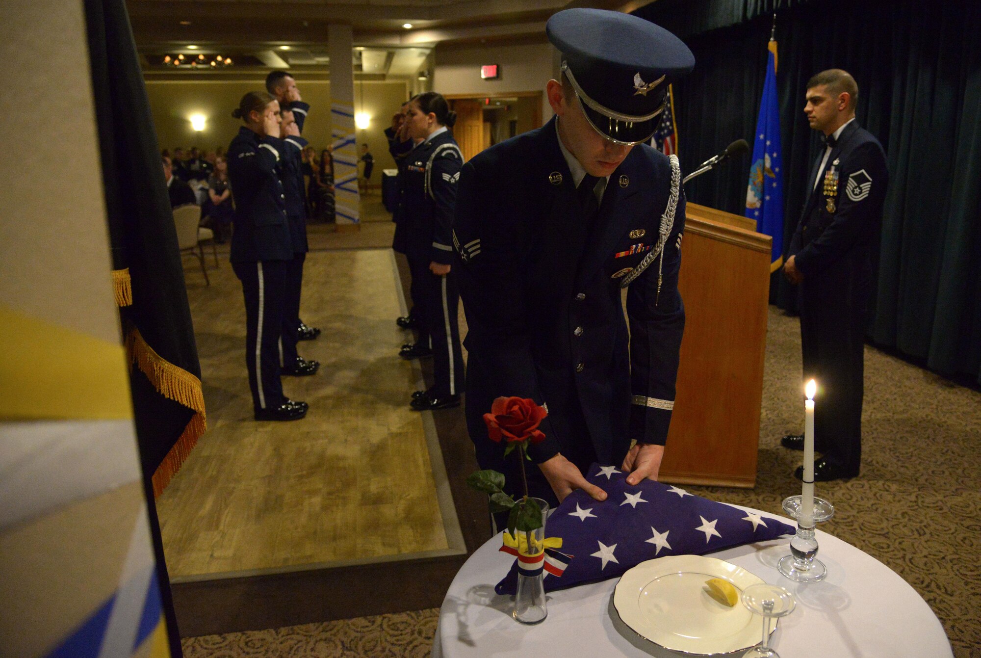 Members of the Cannon honor guard set a table honoring Americas who are still missing in action during the annual awards banquet Feb. 19, 2016, at Cannon Air Force Base, N.M. This table is ceremoniously set to show that Americans shall never forget the brave men and women who answered our nation’s call and served the cause of freedom. (U.S. Air Force photo/Staff Sgt. Alexx Pons) 