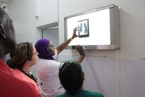 U.S. Army Reserve medical personnel observe as Senegalese Defense Force Lt. Fatou Kine Dieng, an emergency room doctor for Hopital Militaire de Ouakam, places the x-ray against a backlight, Dakar, Senegal, Jan. 27, 2016. Members of the U.S. Army Reserve are in partnership with the SDF to conduct a U.S. Army Africa Medical Readiness Training Exercise, from Jan. 18-29. This exercise is the first of many scheduled throughout the year to demonstrate the strong partnership the U.S. has with its African partners. (U.S. Army photo by Capt. Charles An)