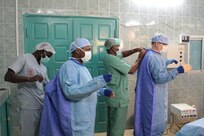 (From left) Spc. Didier Tadida, an operating room specialist for 399th Combat Support Hospital, and Lt. Col. Charles Boggs, a general surgeon for 345th Combat Support Hospital, receive assistance prepping for surgery from members of the Hopital Militaire de Ouakam, Dakar, Senegal, Jan. 27, 2016. Tadida, Boggs and other members of the U.S. Army Reserve are in partnership with the Senegalese Defense Force to conduct a U.S. Army Africa Medical Readiness Training Exercise, from Jan. 18-29. This exercise is the first of many scheduled throughout the year to demonstrate the strong partnership the U.S. has with its African partners. (U.S. Army photo by Capt. Charles An)