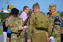 Sept. 19, 2015, Vine Grove, Ky. The 100th Training Division's Commanding General, Brigadier General Jason Walrath, takes a look at a WWII era weapon, owned by one of the local WWII reenactors. Members of the 100th Training Division gathered together for the Autumn Days celebration, in Vine Grove, Ky in late 2015. Soldiers passed out candy to parade-goers, as well as socialized with the local community. WWII era 100th Division reenactors foot marched along side WWII era vehicles, also operated by 100th Division members, signifying the 100th Training Division's rich history and connection to WWII. Overall it was a great event and a great opportunity to bring civilians and Soldiers together! Train em' Tough! (Army photo by: 1LT Alicia Carver, 100th TD)