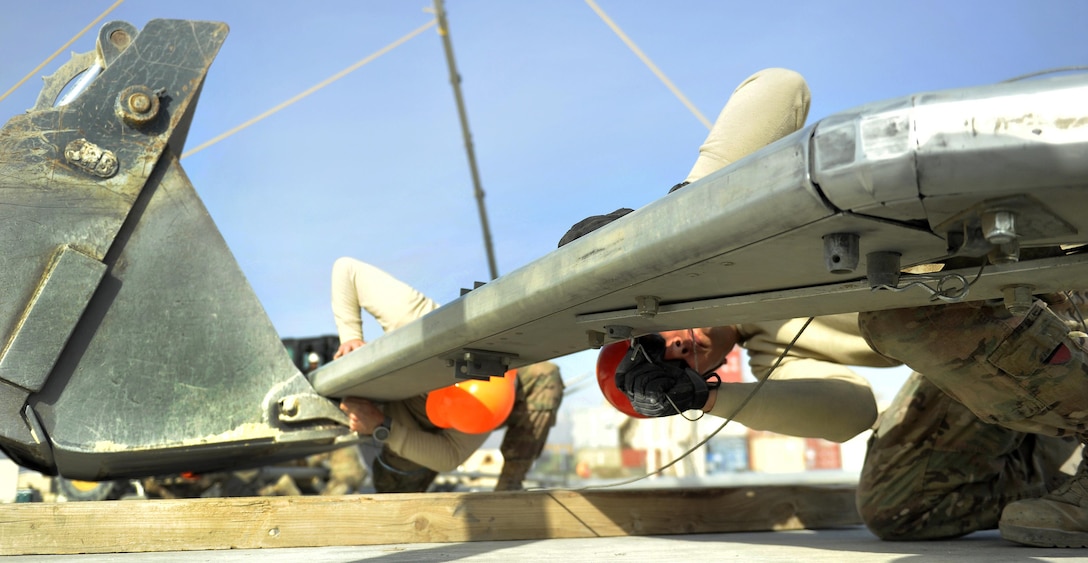 Air Force Staff Sgt. Pashala Lewis secures a pin into the second rib of a large maintenance structure on Bagram Airfield, Afghanistan, Feb. 12, 2016. Lewis is assigned to the 455th Expeditionary Civil Engineer Squadron. Air Force photo by Capt. Bryan Bouchard