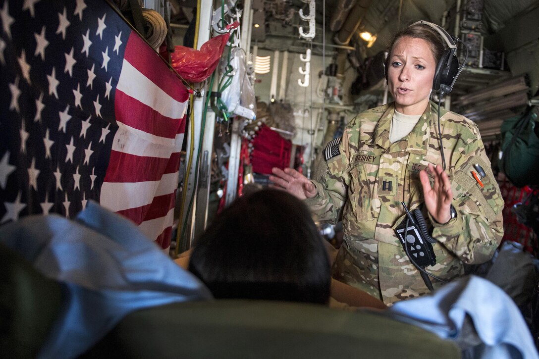 Air Force Capt. Sarabeth Hershey talks with a patient during an aerial medical evacuation mission on Al Udeid Air Base, Qatar, Feb. 11, 2016. Hershey is assigned to the 379th Expeditionary Aeromedical Evacuation Squadron. Air Force photo by Staff Sgt. Corey Hook