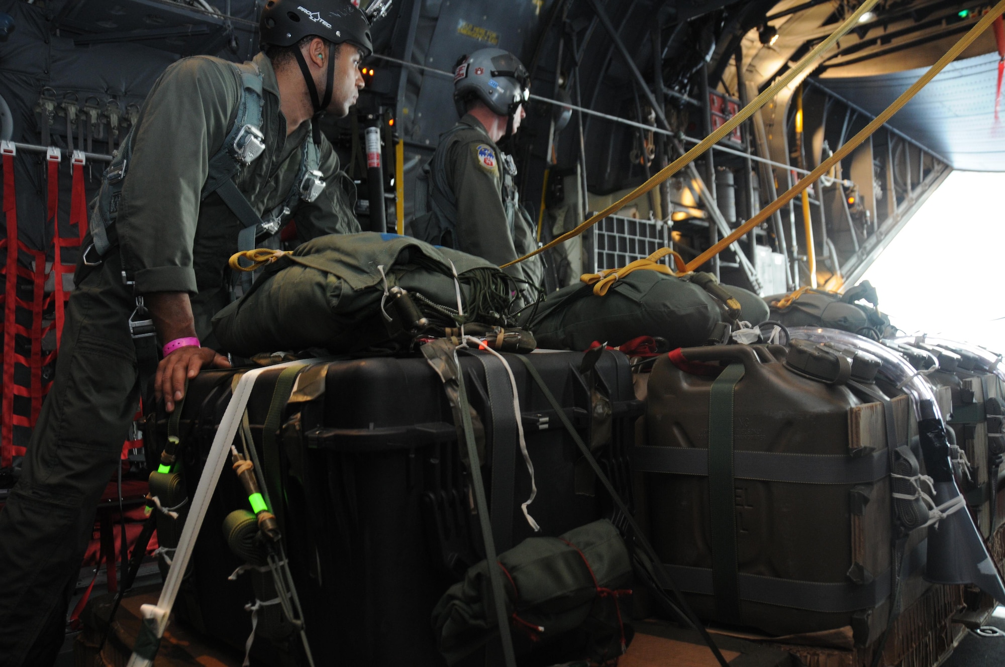 Members of joint forces and the 700th Airlift Squadron prepare pallets before dropping them out of a C-130 Hercules over the Pacific Ocean on Jan. 29, 2016. The pallets were full of supples that were being dropped to rafts. (U.S. Air Force Photo by Senior Airman Miles Wilson)