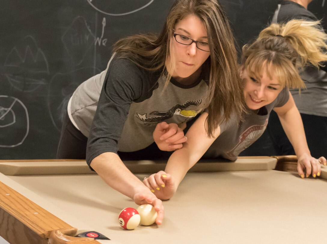 71st Student Squadron spouses Amber Mocalis, left, and Allison Webb perfect their Crud skills during practice Feb. 23, in the 71st STUS heritage room. Mocalis and Webb are training for the Ladies Crud tournament scheduled for 6 p.m., March 4, at the Vance Collocated Club. (Photo by Lt. Col. Mike Drost)