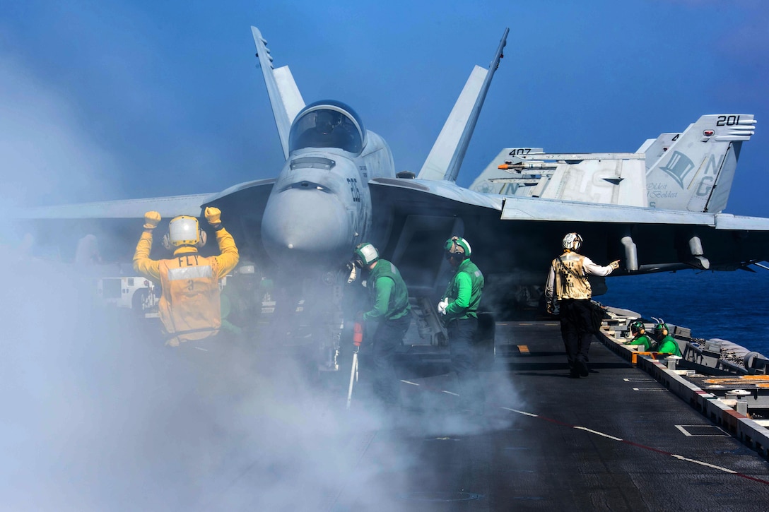 Navy Petty Officer 2nd Class Emmanuel Bonsu directs an F/A-18E Super Hornet assigned to the Tophatters of Strike Fighter Squadron 14 on the flight deck of the aircraft carrier USS John C. Stennis in the Philippine Sea, Feb. 23, 2016. Bonsu is an aviation boatswain's mate. The Stennis is operating as part of the Great Green Fleet on a regularly scheduled 7th Fleet deployment. U.S. Navy photo by Petty Officer 3rd Class Kenneth Rodriguez Santiago
