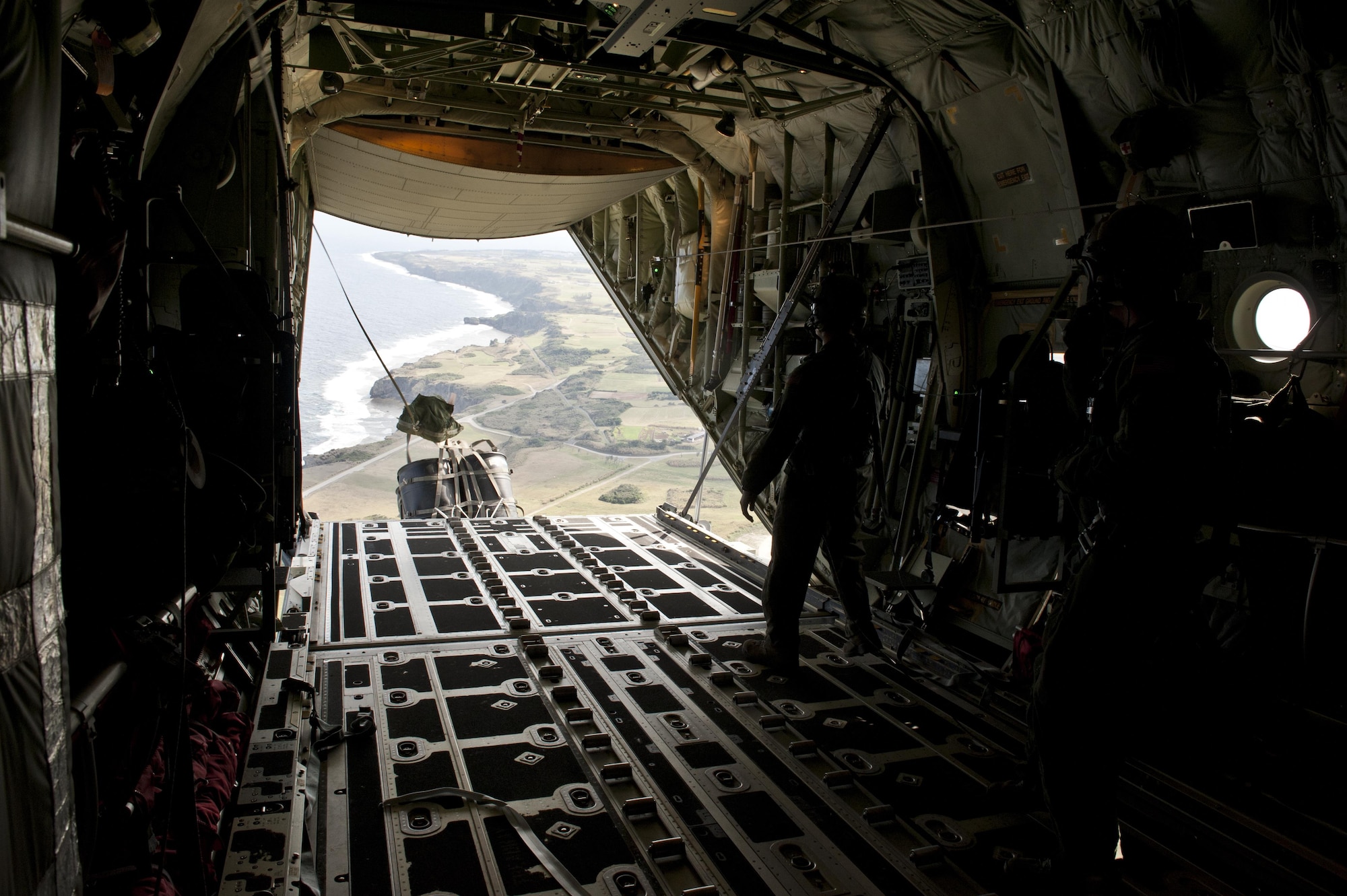 U.S. Air Force Senior Airman Zach Harmon, 17th Special Operations Squadron MC-130J Commando II loadmaster, releases a cargo delivery system over a drop zone during a training exercise Feb. 17, 2016, Okinawa, Japan. Harmon and other 17th SOS Jackals conducted a quick-reaction, full-force sortie that tested the unit's ability to safely execute a five-ship formation flight, cargo drops, short runway landings, and takeoffs, and helicopter air-to-air refueling. (U.S. Air Force photo by Senior Airman Peter Reft/Released)