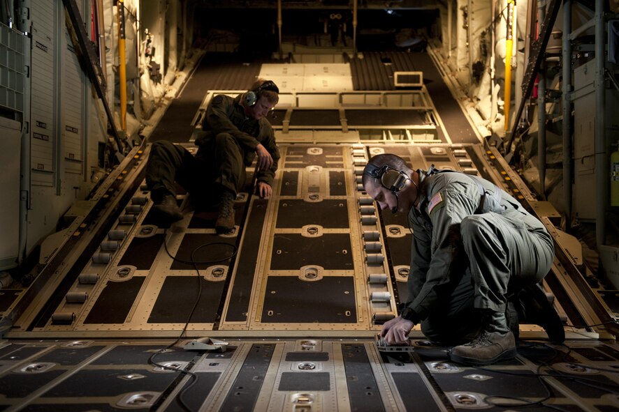 Senior Airmen Tim Manzer and Zach Harmon, 17th Special Operations Squadron MC-130J Commando II loadmasters, secure a cargo deck during a training exercise Feb. 17, 2016, off the coast of Okinawa, Japan. Manzer and Harmon participated in a 17th SOS simulation that tested the unit's ability to safely conduct a quick-reaction, full-force sortie involving a five-ship formation flight, cargo drops, short runway landings and takeoffs, and helicopter air-to-air refueling. (U.S. Air Force photo/Senior Airman Peter Reft)