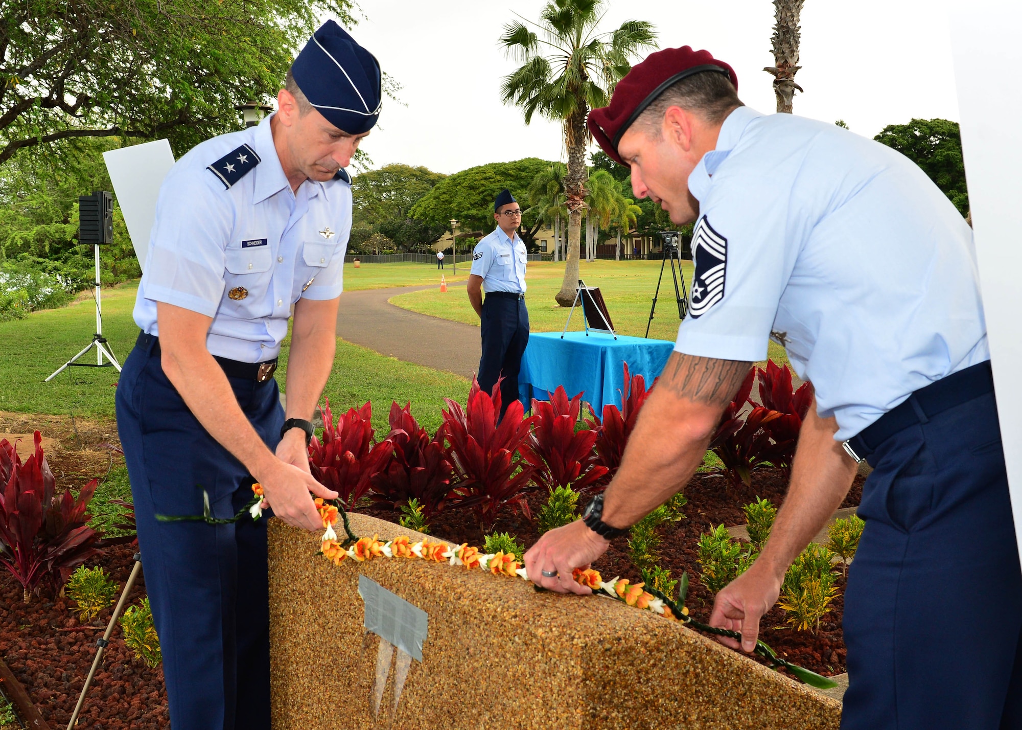 Maj. Gen. Kevin Schneider, Headquarters Pacific Air Forces chief of staff, and Chief Master Sgt. Michael Atkins, Headquarters Pacific Air Forces pararescue functional area manager, place a lei at the top of the Congressional Medal of Honor Memorial during a rededication ceremony at Aloha Aina Park on Joint Base Pearl Harbor-Hickam, Hawaii, Feb. 19, 2016. Base officials rededicated the Medal of Honor Monument at JBPHH to recognized Medal of Honor recipients, Chief Master Sgt. Richard Etchberger and Airman 1st Class William Pitsenbarger. (U.S. Air Force photo by Tech. Sgt. Aaron Oelrich/Released)