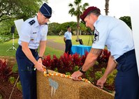 Maj. Gen. Kevin Schneider, Headquarters Pacific Air Forces chief of staff, and Chief Master Sgt. Michael Atkins, Headquarters Pacific Air Forces pararescue functional area manager, place a lei at the top of the Congressional Medal of Honor Memorial during a rededication ceremony at Aloha Aina Park on Joint Base Pearl Harbor-Hickam, Hawaii, Feb. 19, 2016. Base officials rededicated the Medal of Honor Monument at JBPHH to recognized Medal of Honor recipients, Chief Master Sgt. Richard Etchberger and Airman 1st Class William Pitsenbarger. (U.S. Air Force photo by Tech. Sgt. Aaron Oelrich/Released)