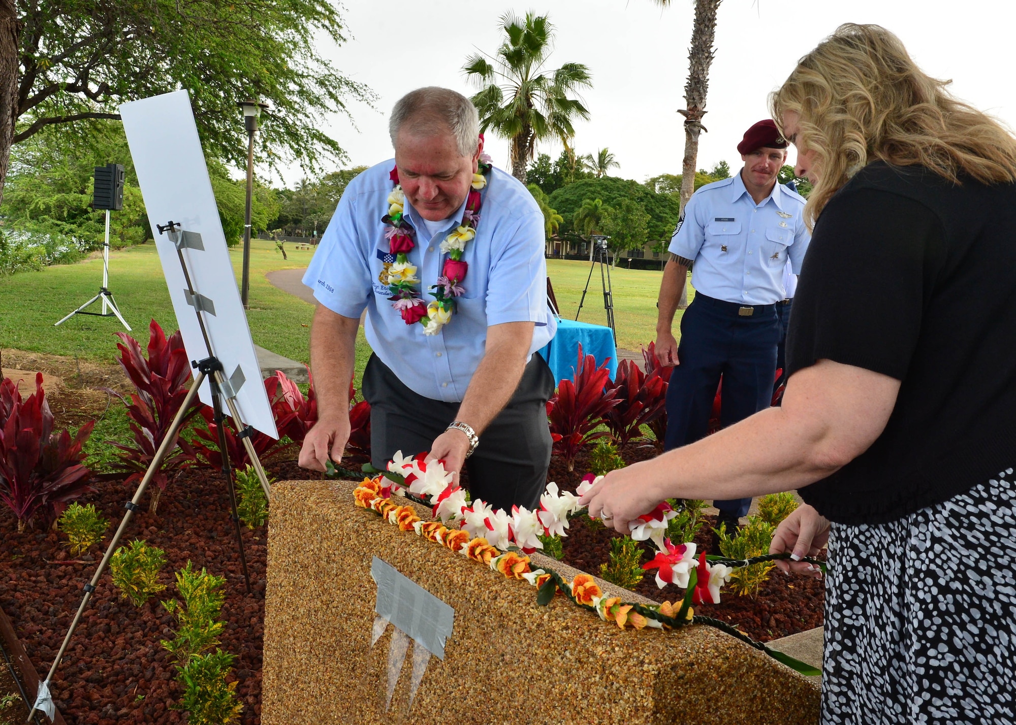Traci Megenney, Chief Master Sgt. Richard Etchberger’s granddaughter, and Cory Etchberger, Chief Master Sgt. Richard Etchberger’s son, place a lei at the top of the Congressional Medal of Honor Memorial during a rededication ceremony at Aloha Aina Park on Joint Base Pearl Harbor-Hickam, Hawaii, Feb. 19, 2016. Base officials rededicated the Medal of Honor Monument at JBPHH to recognized Medal of Honor recipients, Chief Master Sgt. Richard Etchberger and Airman 1st Class William Pitsenbarger. (U.S. Air Force photo by Tech. Sgt. Aaron Oelrich/Released)