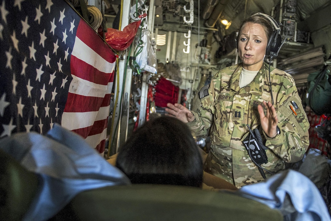 Air Force Capt. Sarabeth Hershey talks with a patient during an aerial medical evacuation mission on Al Udeid Air Base, Qatar, Feb. 11, 2016. Hershey is assigned to the 379th Expeditionary Aeromedical Evacuation Squadron. Air Force photo by Staff Sgt. Corey Hook
