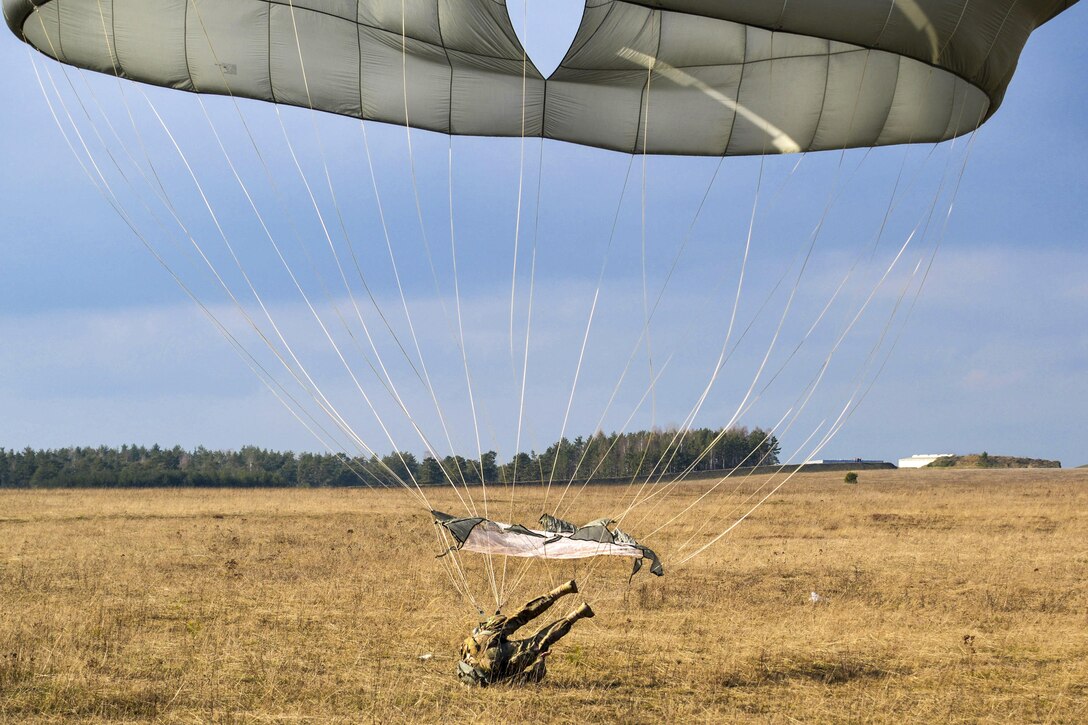 A paratrooper lands on Bunker drop zone after jumping from a UH-60 Black Hawk helicopter at Grafenwoehr Training Area, Germany, Feb. 18, 2016. Army photo by Sgt. Timothy MacDuffie