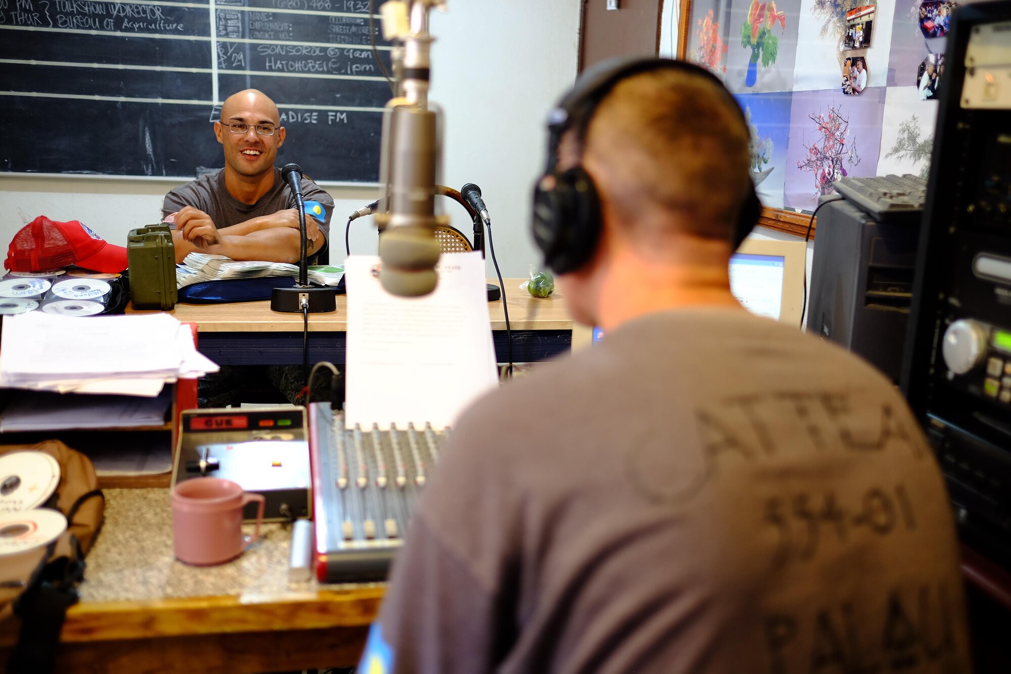 U.S. Air Force Staff Sgt. Joe Hamilton, Civil Action Team 554-01 structural craftsman from the 36th Civil Engineer Squadron at Andersen Air Force Base, Guam, speaks into the microphone during a radio show, Feb. 18, 2016. Hamilton, along with other members of CAT 554-01, hosted a radio program every week informing listeners about current and completed projects, along with playing American music. (U.S. Air Force photo by Staff Sgt. Christopher Stoltz/Released)