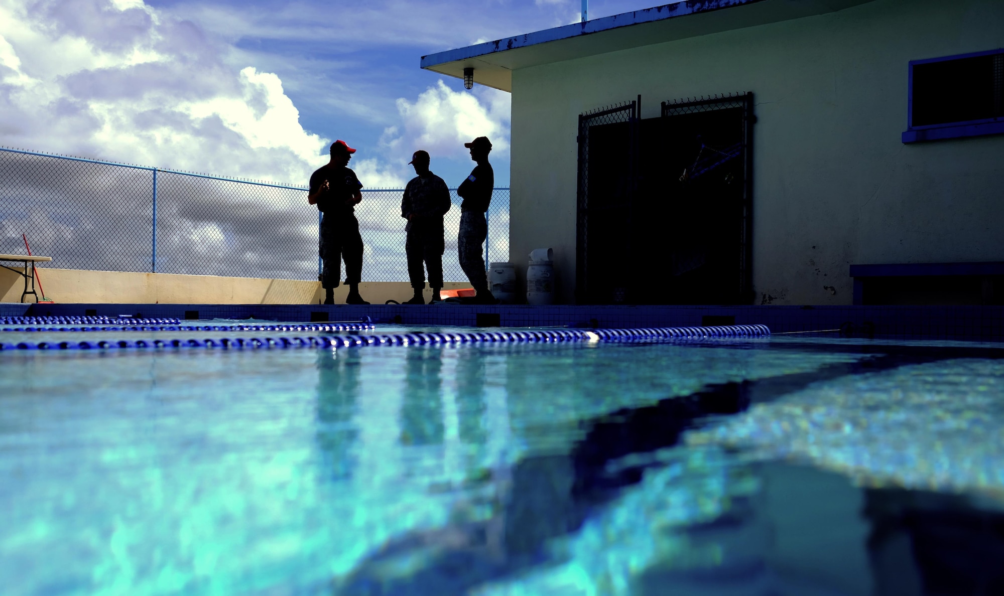 Members of Civil Action Team 554-01 made up of Airmen from the 554th Red Horse Squardon and 36th Civil Engineer Squadron at Andersen Air Force Base, Guam discuss their recently completed project – The Palau National Olympic Swimming Pool.  The pool measured nearly 88,000 cubic feet and was stripped, resurfaced and re-tiled. (U.S. Air Force photo by Staff Sgt. Christopher Stoltz/Released)