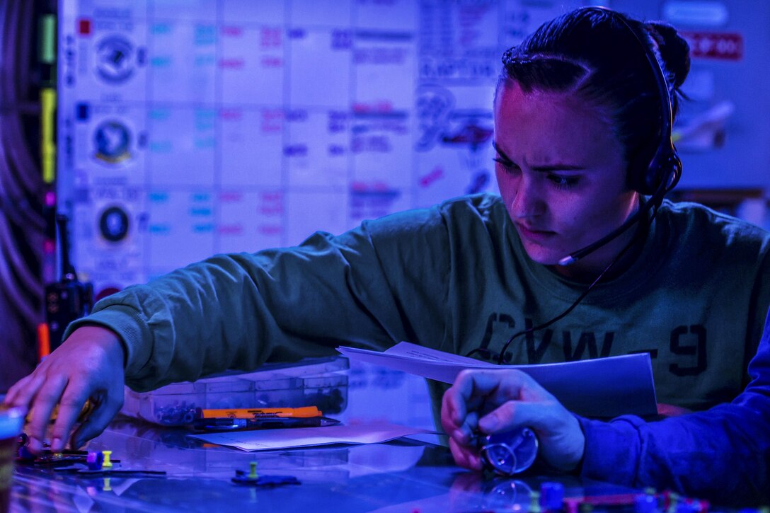 Navy Seaman Gaylen Bataille positions an aircraft model on the Ouija board in the flight deck control room of the USS John C. Stennis in the Philippine Sea, Feb. 24, 2016. Sailors use the Ouija board to track the status and movement of aircraft on the Stennis in real time. The Stennis provides a ready force to support security and stability in the Indo-Asia-Pacific region. U.S. Navy photo by Petty Officer 3rd Class Andre T. Richard