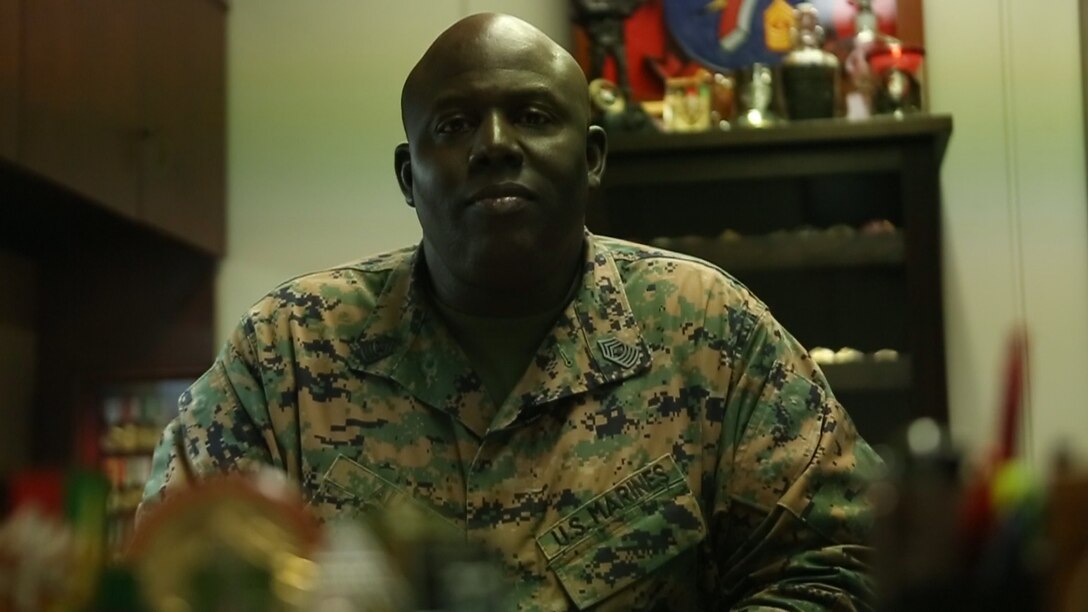 Pictured is Master Gunnery Sgt. Arthur Allen III sitting behind his desk on Camp Courtney. He enlisted in 1986 and has served nearly 31 years in the Marine Corps. During his time in, he has seen a lot, including Operations Desert Shield and Desert Storm in Saudi and Kuwait, Operation Iraqi Freedom in Iraq, and Operation Enduring Freedom in Afghanistan. Allen is the communications chief of III Marine Expeditionary Force. (U.S. Marine Corps photo by Cpl. Tyler Ngiraswei/Released)