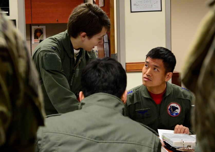 U.S. Air Force 1st Lt. Samantha Latch, a 25th Fighter Squadron pilot, speaks with South Korean air force Capt. Ahn Hae-chul, a 237th FS pilot, during a preflight brief at Buddy Wing 16-2 on Osan Air Base, South Korea, Feb. 23, 2016. During Buddy Wing, pilots coordinated mission planning for contingencies that may arise in the event of real-world foreign aggression. (U.S. Air Force photo/Senior Airman Kristin High)