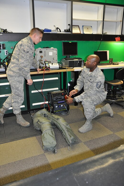 (Right) Master Sgt. Kevin Younger, 706th Fighter Squadron, monitors Airman First Class Paul Niekelski, 422nd Test and Evaluation Squadron Aircrew Flight Equipment apprentice, conducting a pressurization test that checks for leaks in the F-35 G-suit here Feb. 22. (U.S. Air Force photo/Maj. Jessica D'Ambrosio)