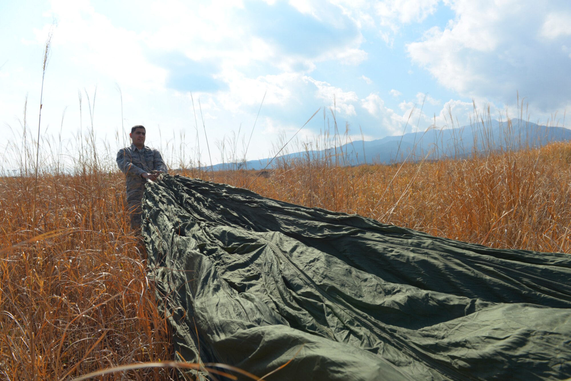 Staff Sgt. Joshua Mcdonald, 374th Logistics Readiness Squadron aerial delivery supervisor, recovers a parachute at the base of Mt. Fuji, Japan, Feb. 2, 2016. Airmen who inspect, maintain and pack parachutes are known as riggers. After technical school, they attend a 3.5-month course to earn their rigger wings. (U.S. Air Force photo by Airman 1st Class Elizabeth Baker/Released) 