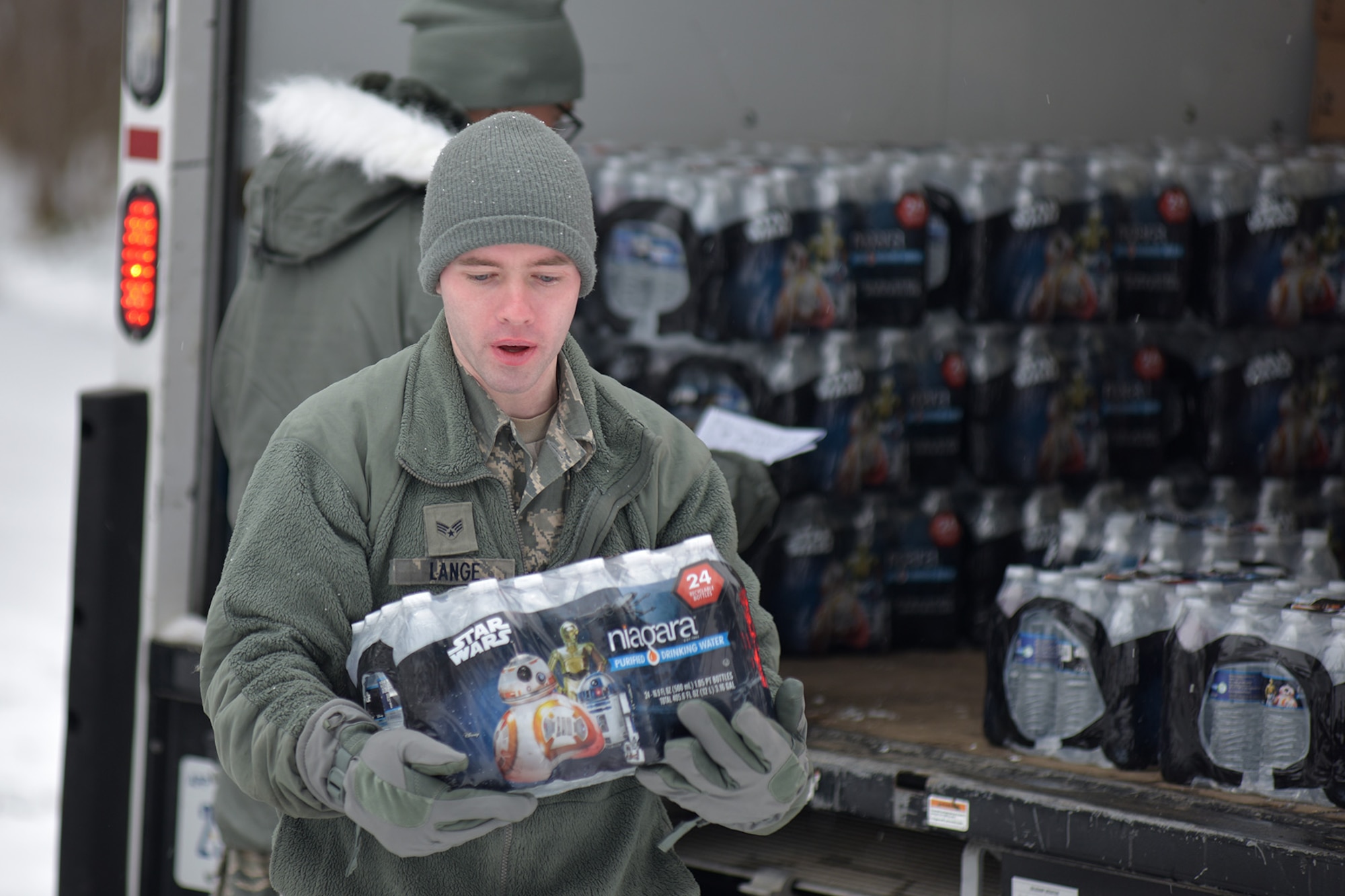 Michigan Air National Guard Senior Airman Scott Lange, a member of the 127th Wing assigned to Selfridge Air National Guard Base, carries a case of water during water delivery efforts in Flint, Mich., Jan. 21, 2016. Selfridge Air National Guard Base has served as a hub for water distribution efforts in Flint. (U.S. Air National Guard photo)