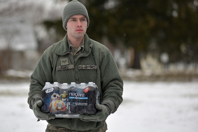 Michigan Air National Guard Senior Airman Scott Lange, a member of the 127th Wing assigned to Selfridge Air National Guard Base, carries a case of water during water delivery efforts in Flint, Mich., Jan. 21, 2016. Selfridge Air National Guard Base has served as a hub for water distribution efforts in Flint. (U.S. Air National Guard photo)