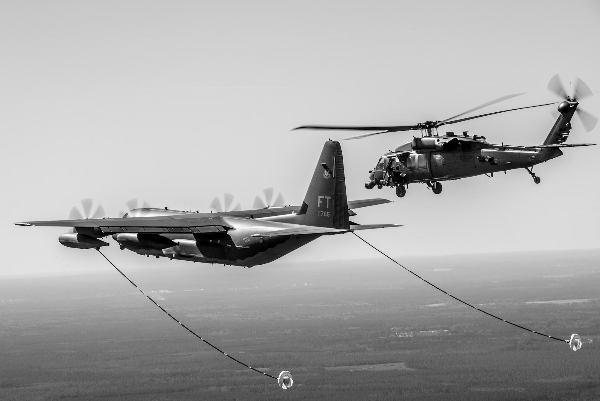 An HH-60G Pave Hawk from the 41st Rescue Squadron flies towards an HC-130J Combat King II from the 71st RQS during aerial refueling operations, Feb. 18, 2016, in the skies over Moody Air Force Base, Ga.  Multiple U.S. Air Force aircraft within Air Combat Command conducted joint aerial training at Grand Bay Bombing and Gunnery Range. During the training, the aircraft conducted tactical air and ground maneuvers, as well as weapons training. (U.S. Air Force photo by Senior Airman Ryan Callaghan/Released)




