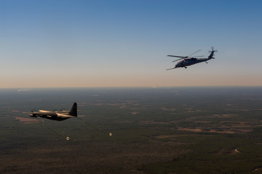 An HH-60G Pave Hawk from the 41st Rescue Squadron flies towards an HC-130J Combat King II from the 71st RQS during aerial refueling operations, Feb. 18, 2016, in the skies over Moody Air Force Base, Ga.   Multiple U.S. Air Force aircraft within Air Combat Command conducted joint aerial training at Grand Bay Bombing and Gunnery Range. During the training, the aircraft conducted tactical air and ground maneuvers, as well as weapons training. (U.S. Air Force photo by Senior Airman Ryan Callaghan/Released)




