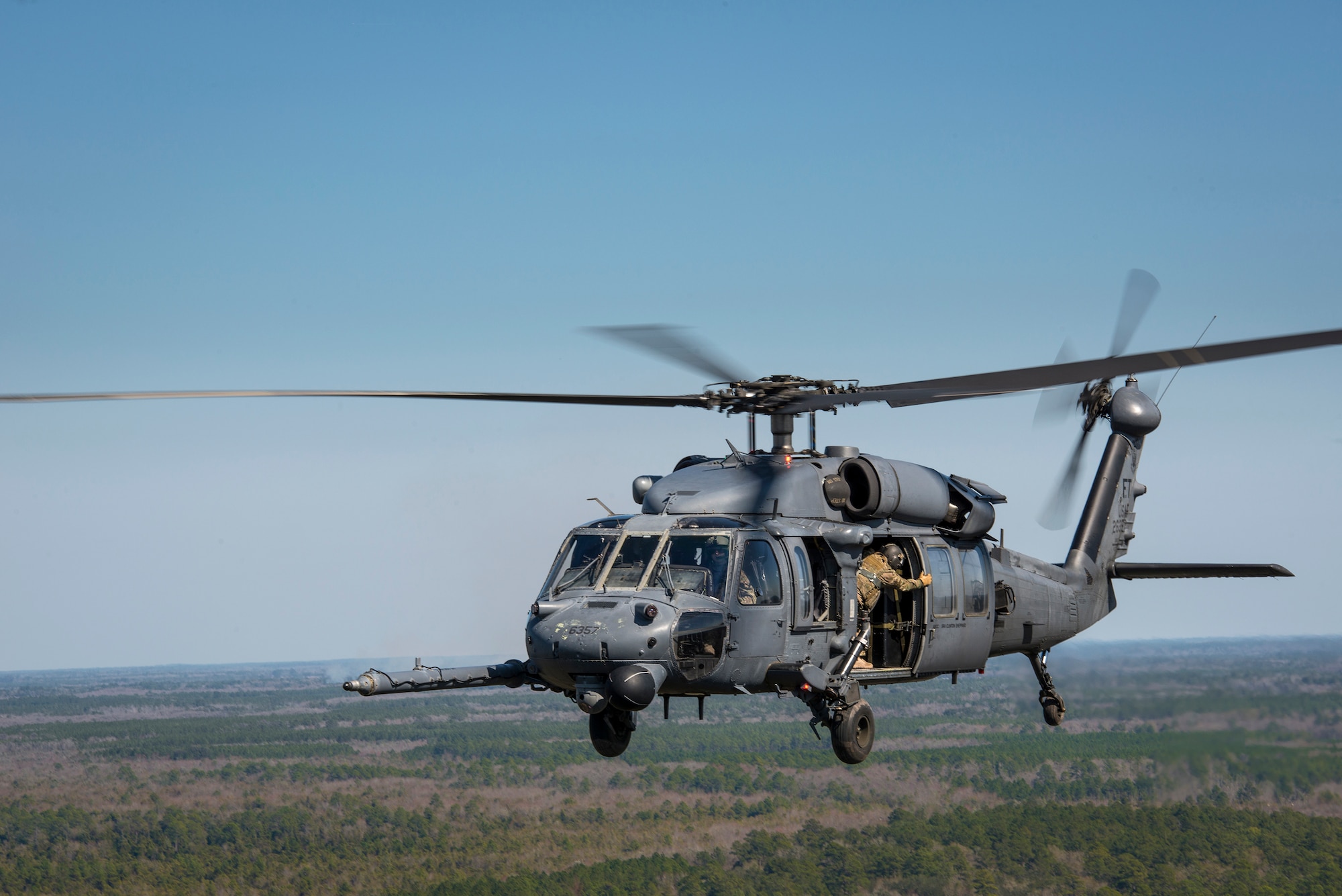 A special missions aviator from the 41st Rescue Squadron closes the door on an HH-60G Pave Hawk, Feb. 11, 2016, in the skies over Moody Air Force Base, Ga.  Multiple U.S. Air Force aircraft within Air Combat Command conducted joint aerial training at Grand Bay Bombing and Gunnery Range. During the training, the aircraft conducted tactical air and ground maneuvers, as well as weapons training. (U.S. Air Force photo by Senior Airman Ryan Callaghan/Released)


