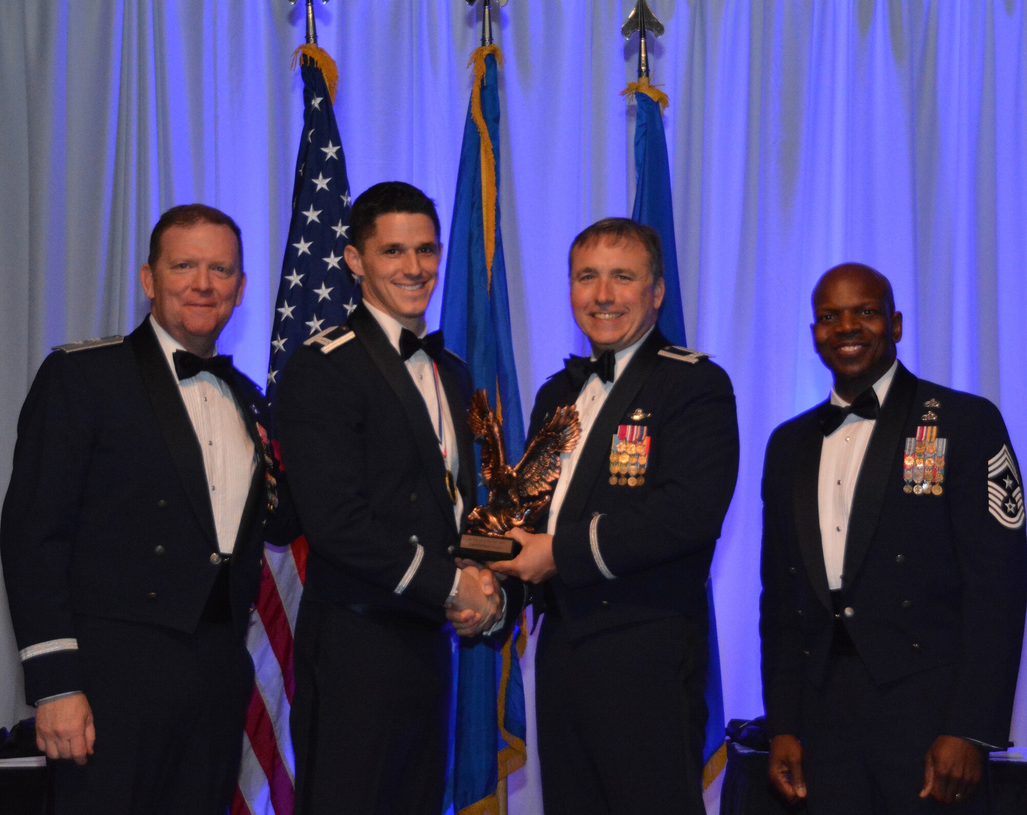 NAVAL AIR STATION FORT WORTH JOINT RESERVE BASE, Texas – Capt. Matthew Tucker, 495th Fighter Group, Tyndall Air Force Base, Fla., a geographically-separated unit, accepts the 2015 Company Grade Officer of the Year award from Col. John Breazeale, 301st Fighter Wing commander, Feb. 20 at the Fort Worth Stockyards, Texas. Maj. Gen. Richard Scobee, 10th Air Force commander and keynote speaker, accompanied Breazeale and Chief Master Sgt. Terry Goines, 301st Fighter Wing command chief, on stage to recognize and congratulate the winners. (U.S. Air Force photo by Staff Sgt. Samantha Mathison)