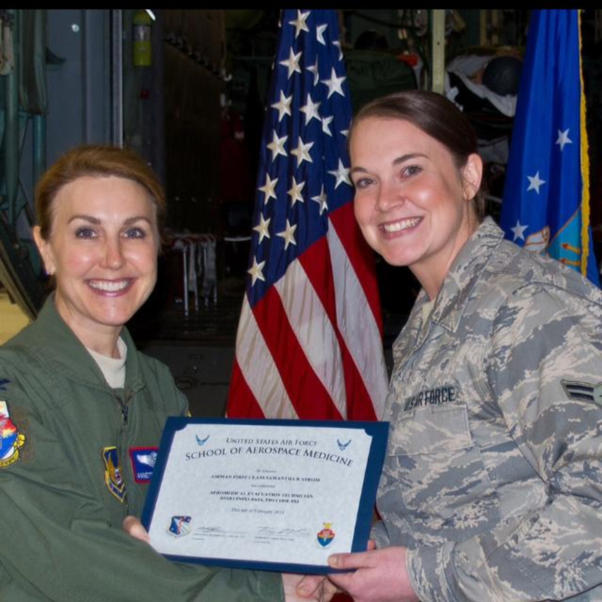 Senior Airman Samantha Strom poses for a picture as she accepts her certificate for graduating from the Air Force School of Aerospace Medicine. Strom and Capt. Bradley Stone, both assigned to the 932nd Aeromedical Evacuation Squadron (Reserve), were touring Pearl Harbor, Hawaii, during down time on a deployment Feb. 18 when they aided in the rescue of helicopter crash victims. (Courtesy photo)