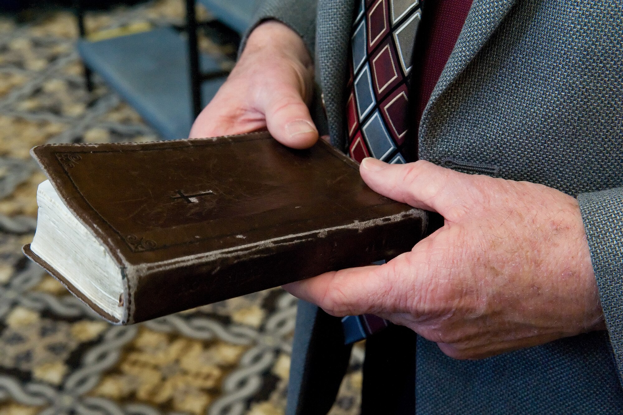 Retired Chaplain (Maj. Gen.) Cecil Richardson, former Chief of Air Force Chaplains, Headquarters U.S. Air Force, Washington, D.C., holds his Bible while socializing with attendees prior to the National Prayer Luncheon Feb. 18, 2016, at the Landings on Dover Air Force Base, Del. As the keynote speaker, Richardson delivered his messages at the luncheon with this year's topic on Spiritual Resiliency. (U.S. Air Force photo/Roland Balik)