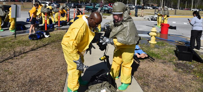 Navy Petty Officer 2nd Class Jacqueline Holman, a hospital corpsman at Naval
Health Clinic Charleston, with fellow corpsman, Petty Officer 1st Class Terro
Walker, prepare his Powered Air Purifying Respirator during a timed
Chemical, Biological, Radiological, Nuclear and Explosives exercise Feb. 18.
In the background, NHCC's medical first responders don CBRNE protective
suits to prepare for the exercise, during which, they practiced
life-saving skills required to triage, initiate field treatment,
decontaminate and save victims during a CBRNE event. (Navy photo by Petty
Officer 3rd Class Robert Jackson)
