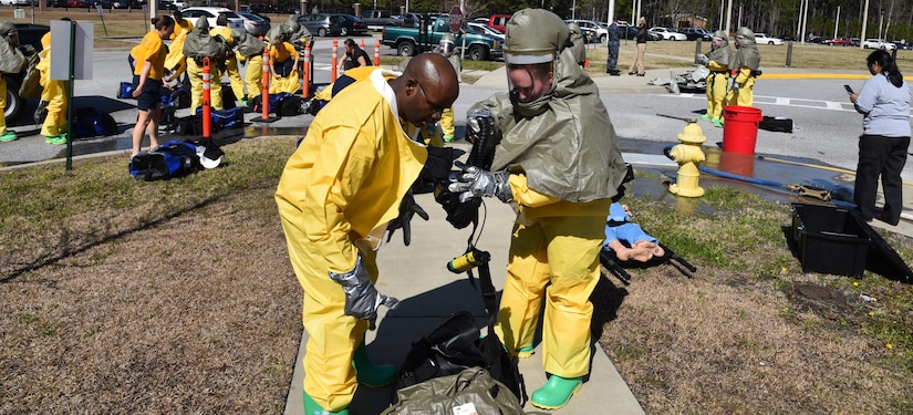 Navy Petty Officer 2nd Class Jacqueline Holman, a hospital corpsman at Naval
Health Clinic Charleston, with fellow corpsman, Petty Officer 1st Class Terro
Walker, prepare his Powered Air Purifying Respirator during a timed
Chemical, Biological, Radiological, Nuclear and Explosives exercise Feb. 18.
In the background, NHCC's medical first responders don CBRNE protective
suits to prepare for the exercise, during which, they practiced
life-saving skills required to triage, initiate field treatment,
decontaminate and save victims during a CBRNE event. (Navy photo by Petty
Officer 3rd Class Robert Jackson)
